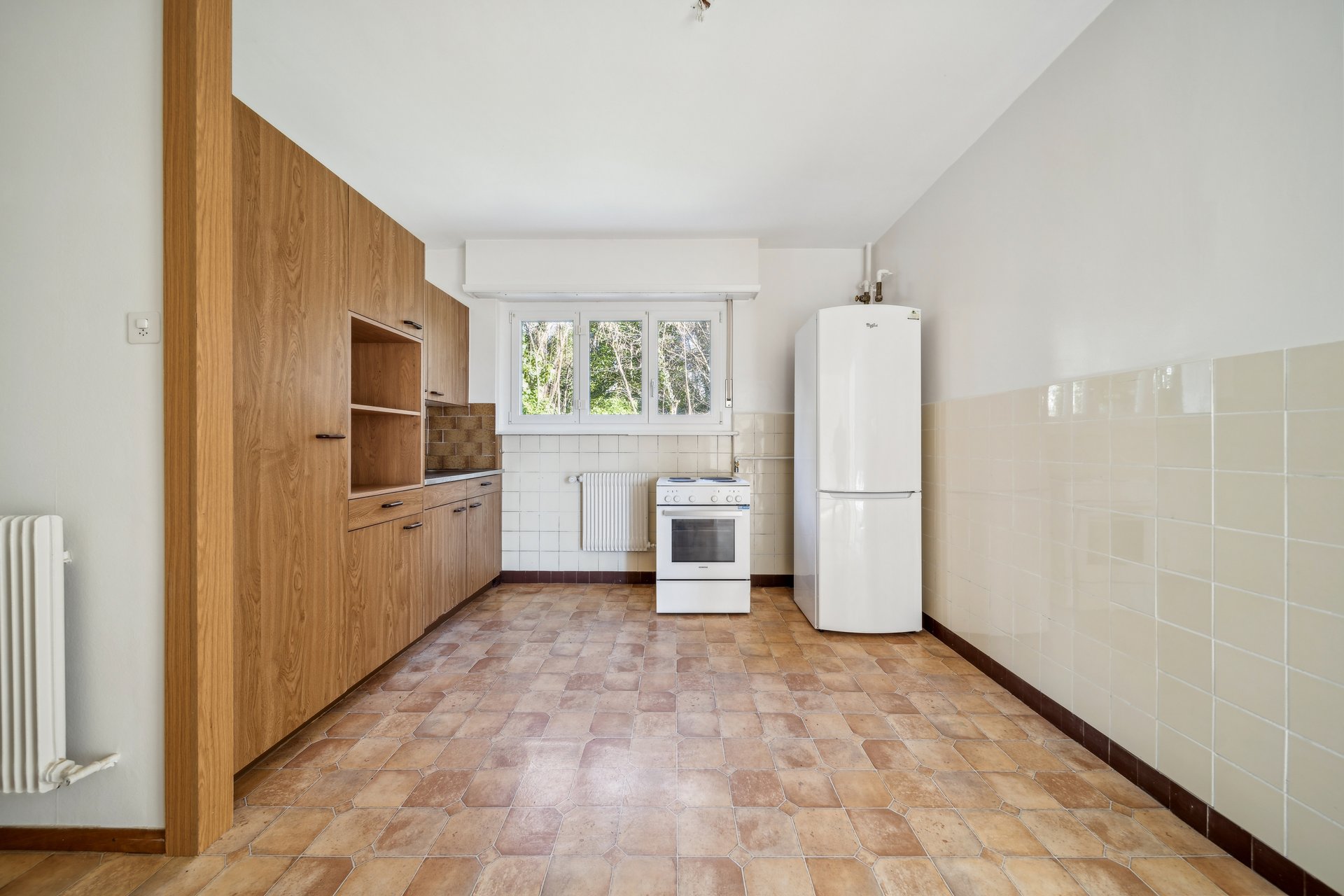 Küche mit Holzfronten und Fliesenboden