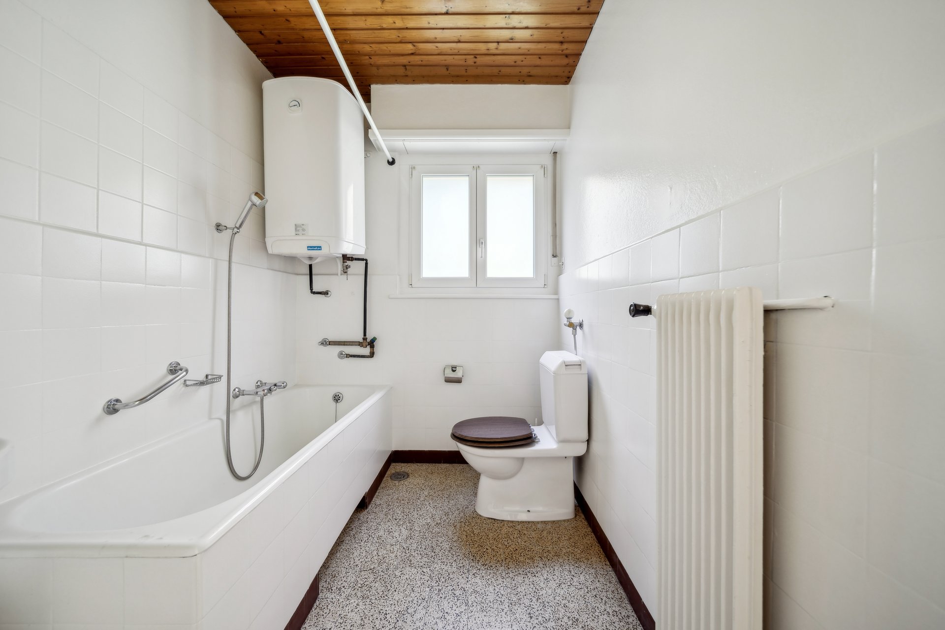 Kleines Badezimmer mit Badewanne und WC
