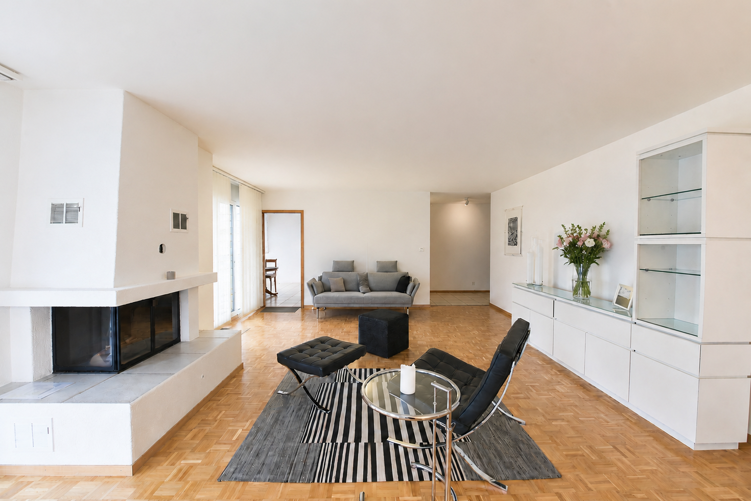 Großzügiges Wohnzimmer mit Kamin und moderner Sitzgruppe