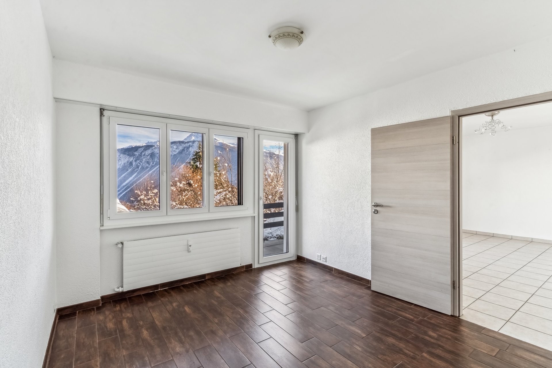 Leerer Raum mit Bergblick und Zugang zum Balkon