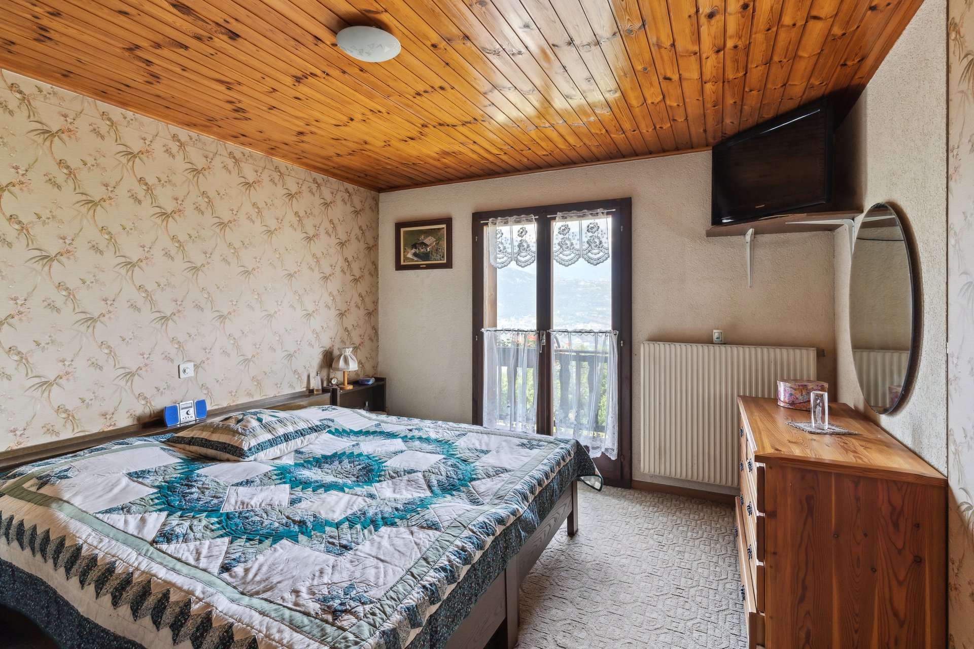 Schlafzimmer mit Holzdecke und Bergblick