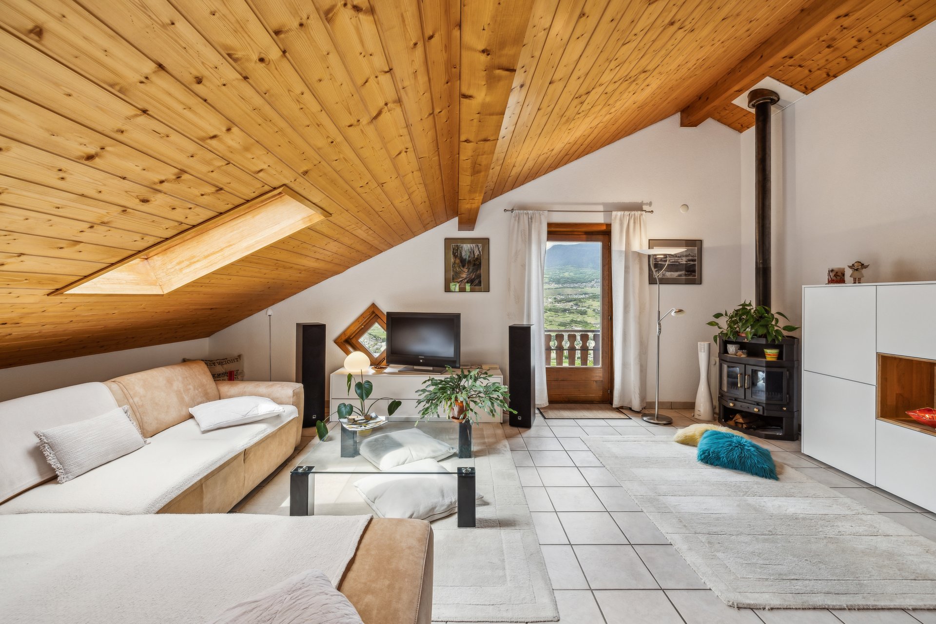 Gemütliches Dachgeschoss-Wohnzimmer mit Holzdecke und Bergblick