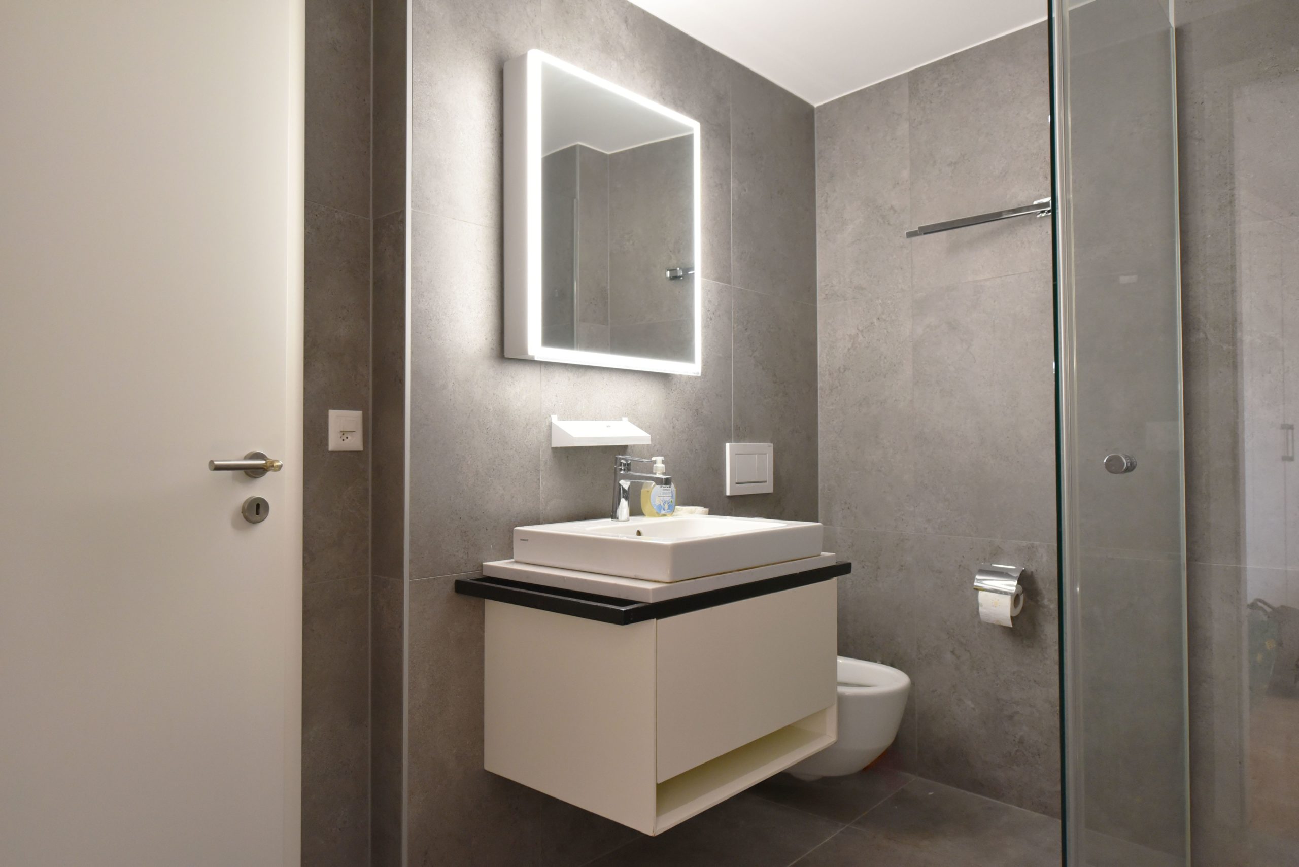 Modernes Bad mit beleuchtetem Spiegel