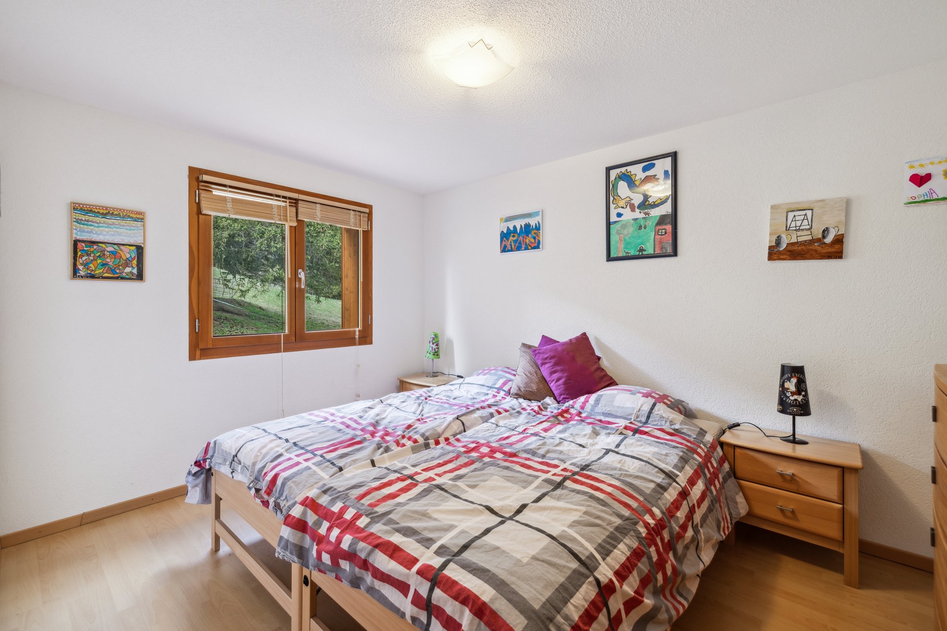 Helles Schlafzimmer mit Doppelbett und Holzfenster