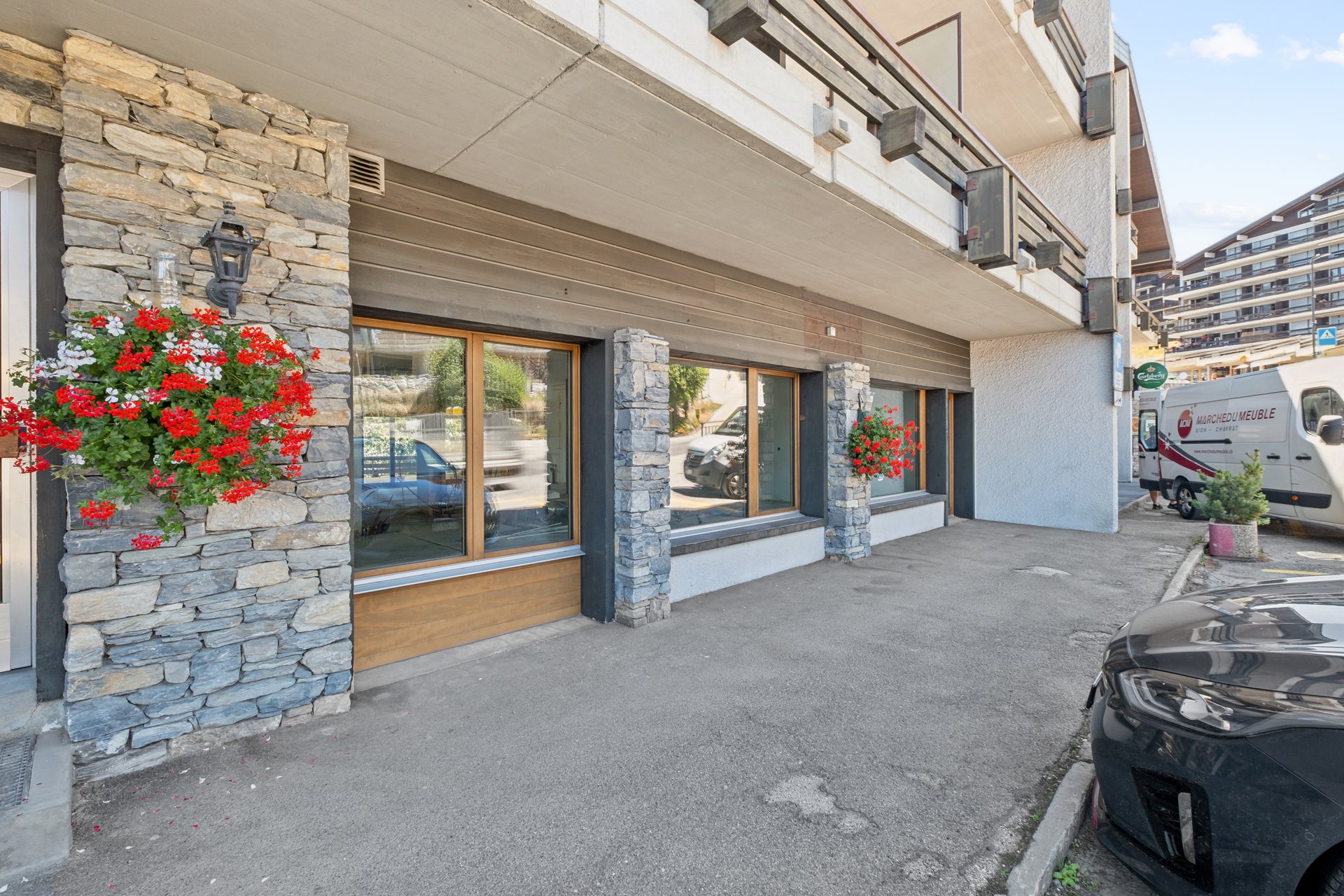 Straßenansicht eines Gebäudes mit Steinverkleidung und Balkon