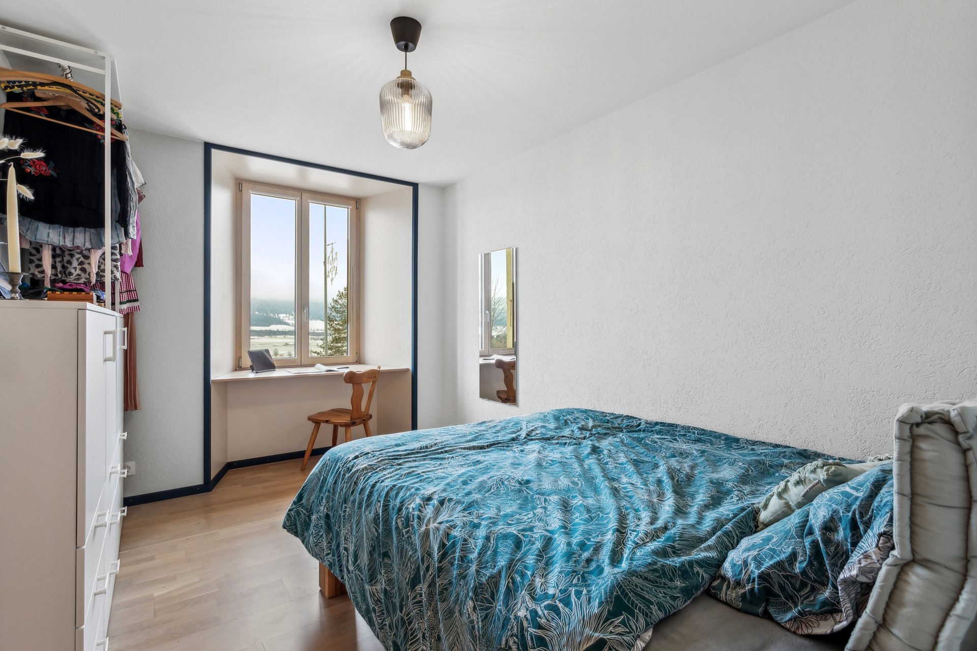 Helles Schlafzimmer mit Fensternische und Blick ins Grüne