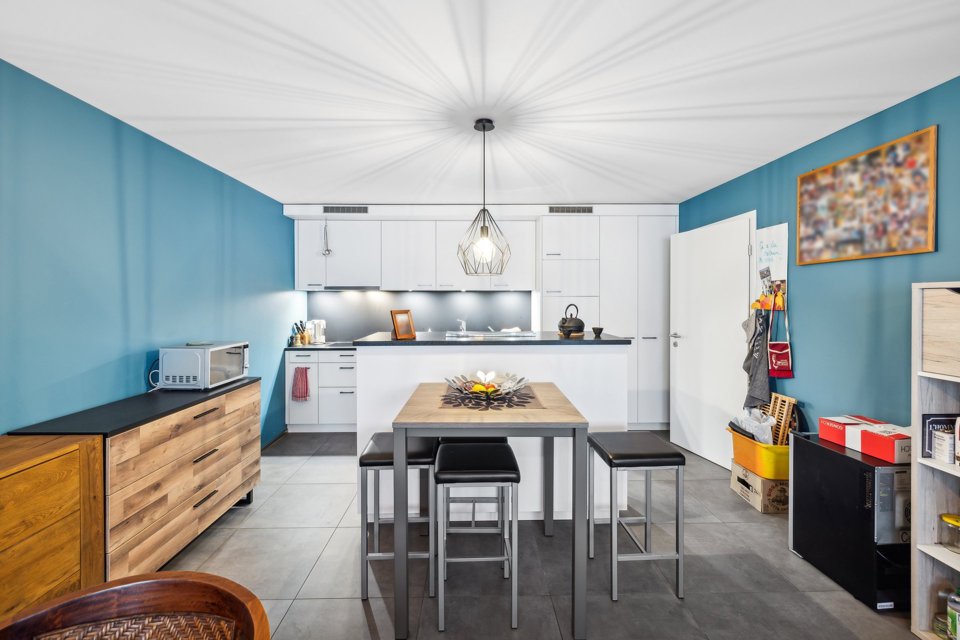 Moderne Küche mit blau gestrichenen Wänden und Kochinsel