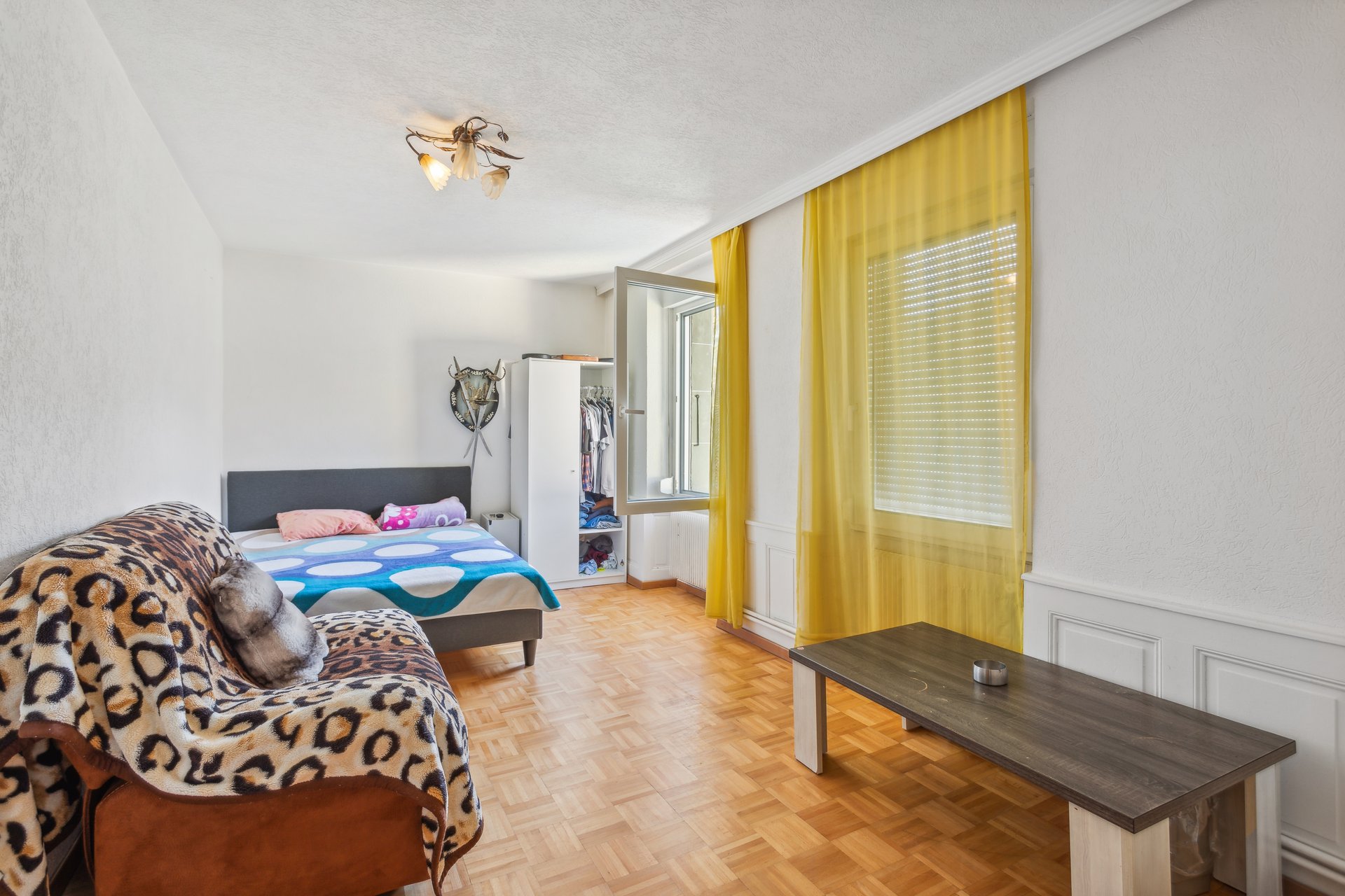 Helles Schlafzimmer mit Sofa und Kleiderschrank