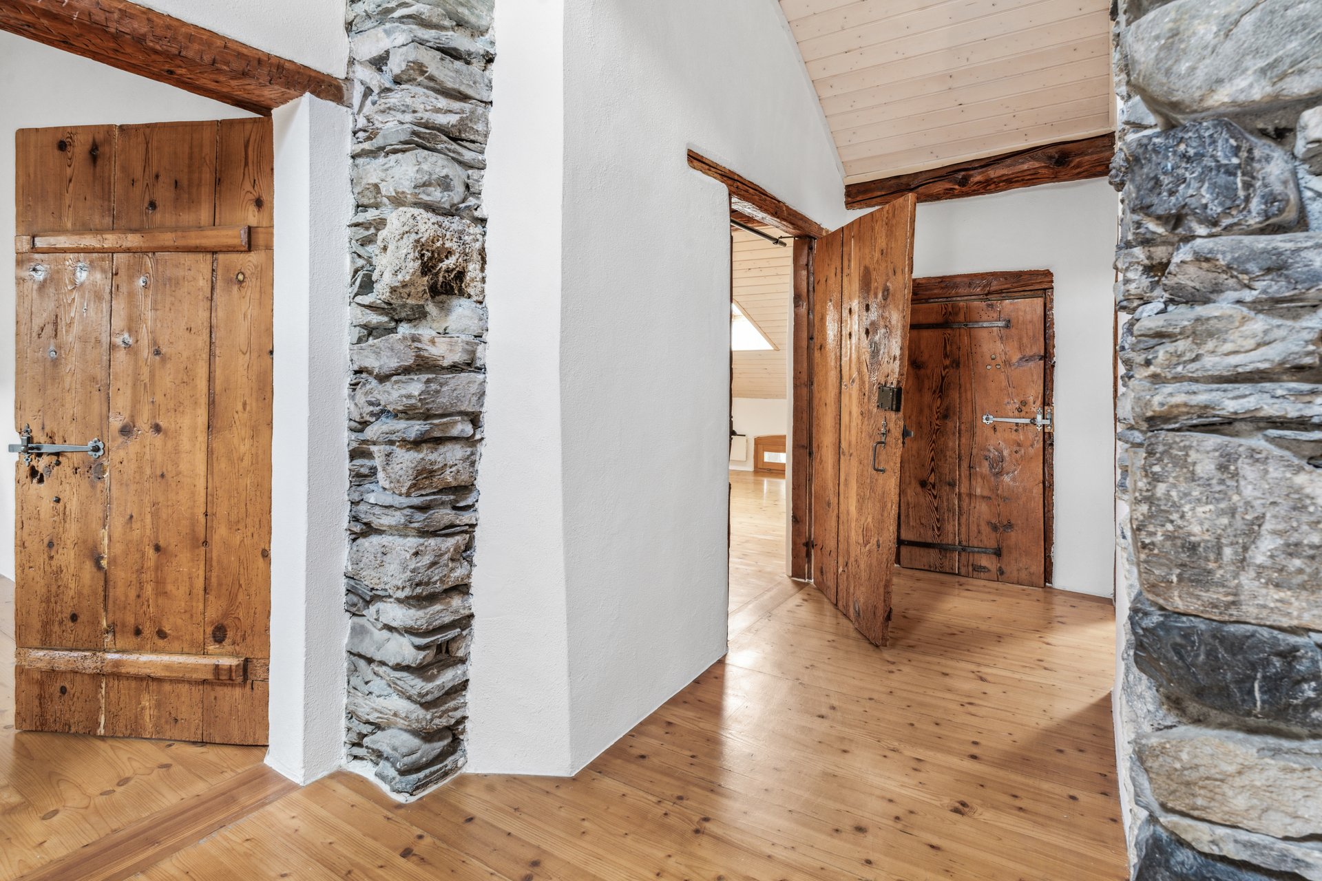Rustikale Innenansicht mit Holztüren und Naturstein