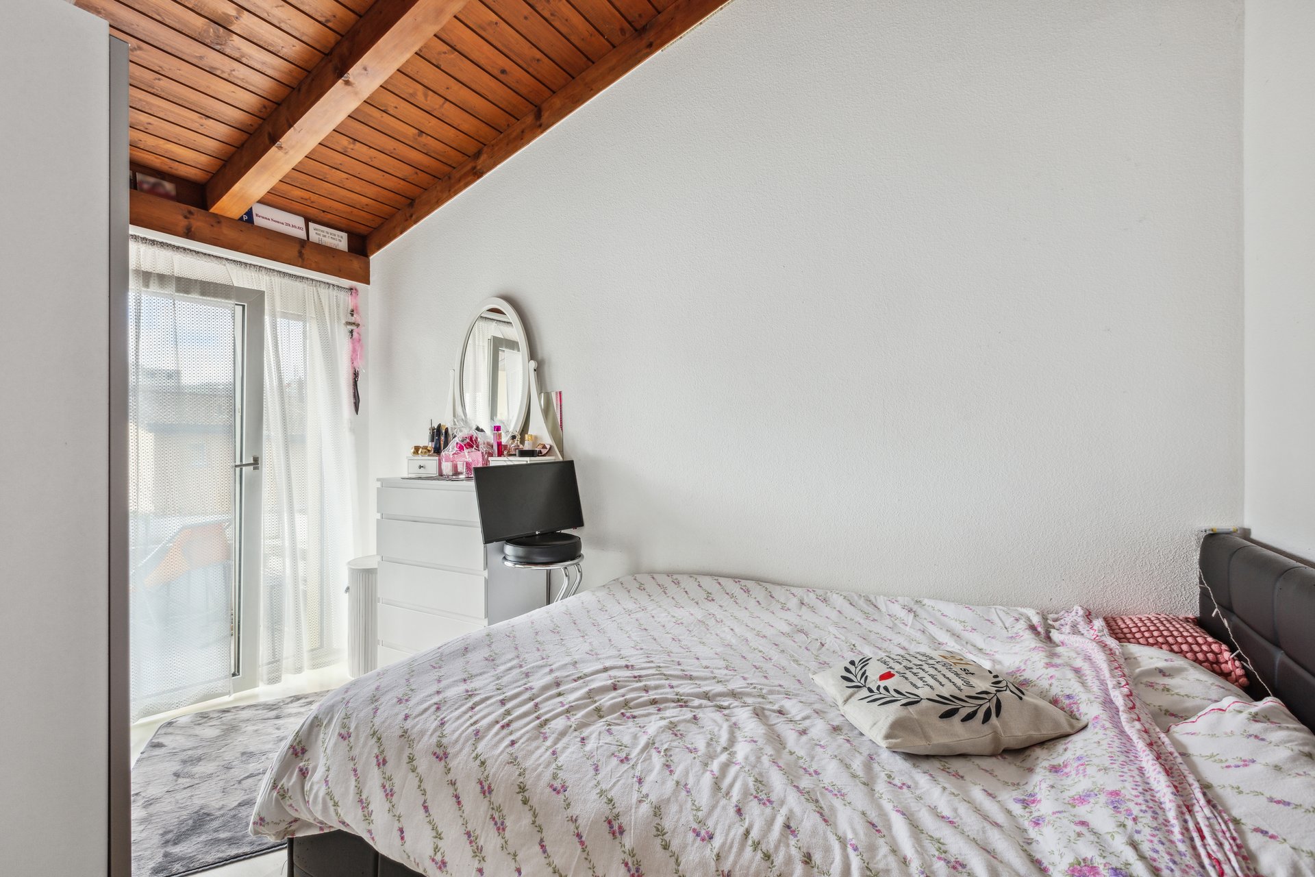 Schlafzimmer mit Dachschräge und kleinem Balkonzugang