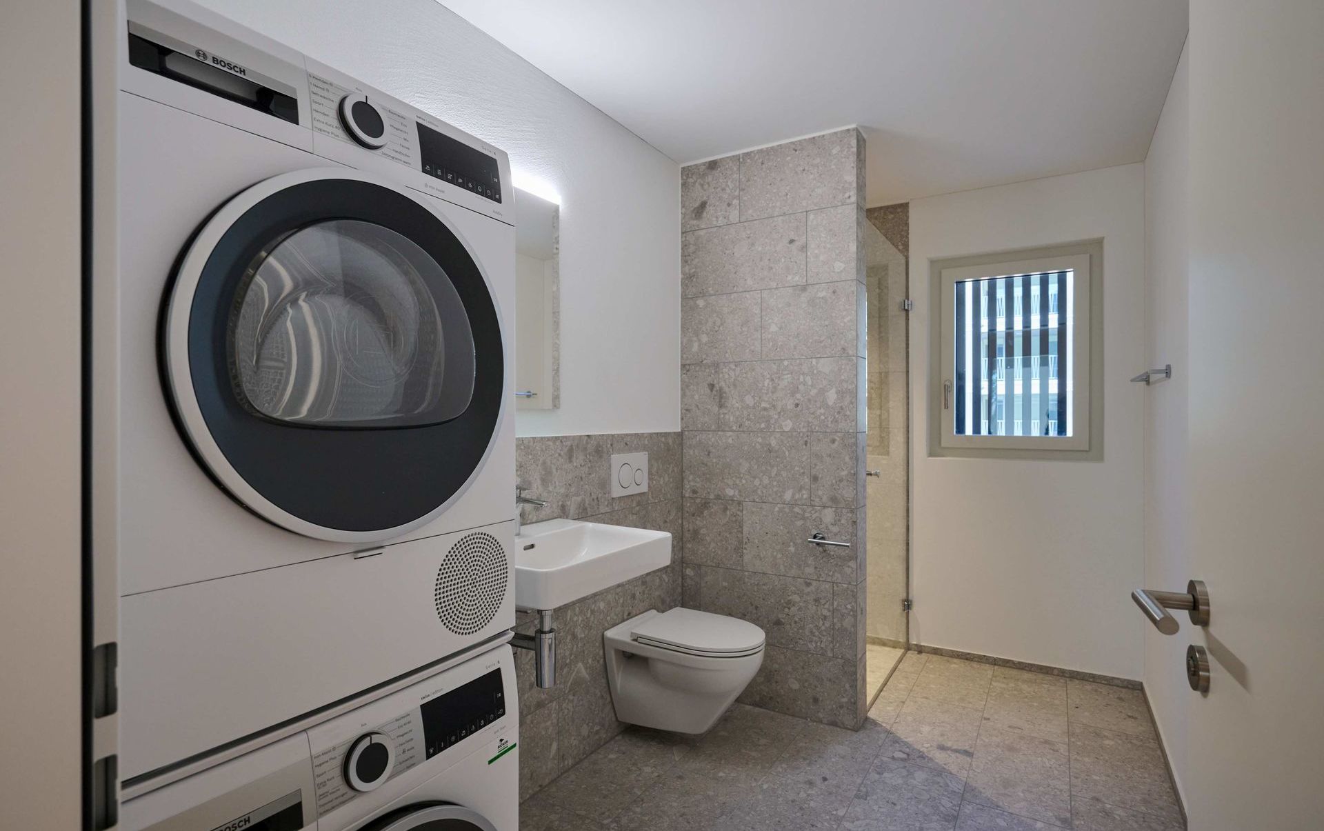 Modernes Badezimmer mit Waschmaschinen- und WC-Nische