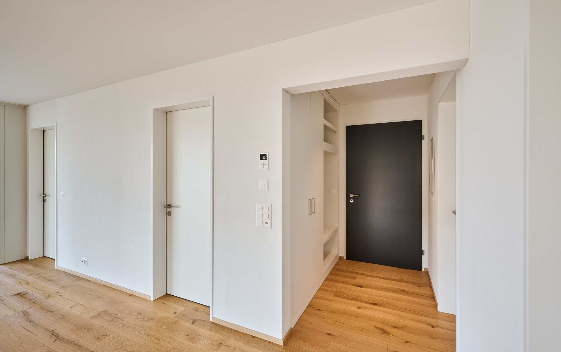 Heller Flur mit Holzboden und mehreren Türen