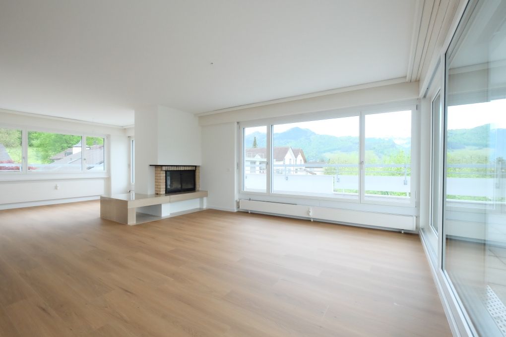 Heller Wohnraum mit Kamin und Panoramafenstern