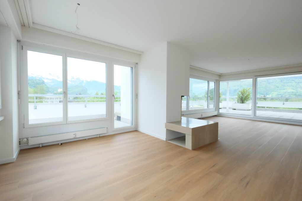 Heller Wohnraum mit großer Fensterfront und Bergblick