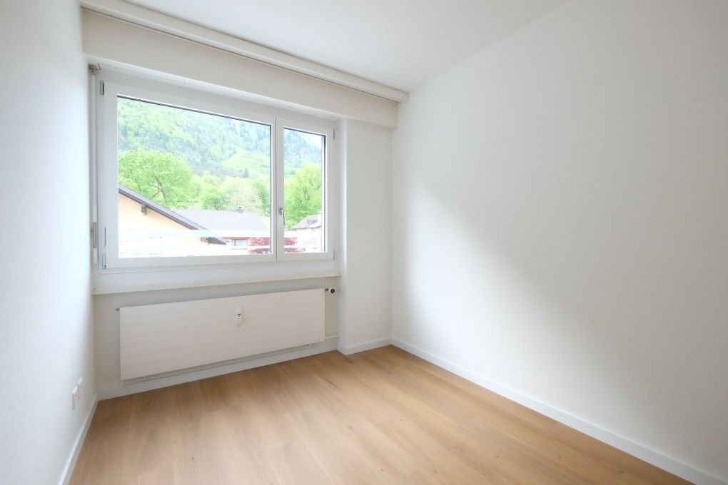 Helles leeres Zimmer mit Fensterblick ins Grüne