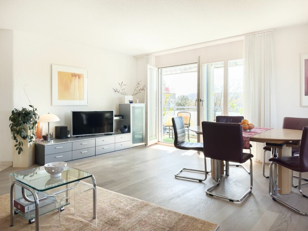 Helles Wohnzimmer mit Essbereich und Balkonzugang