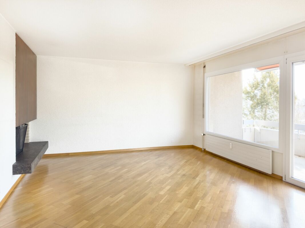 Heller Wohnraum mit Parkett und großem Fenster