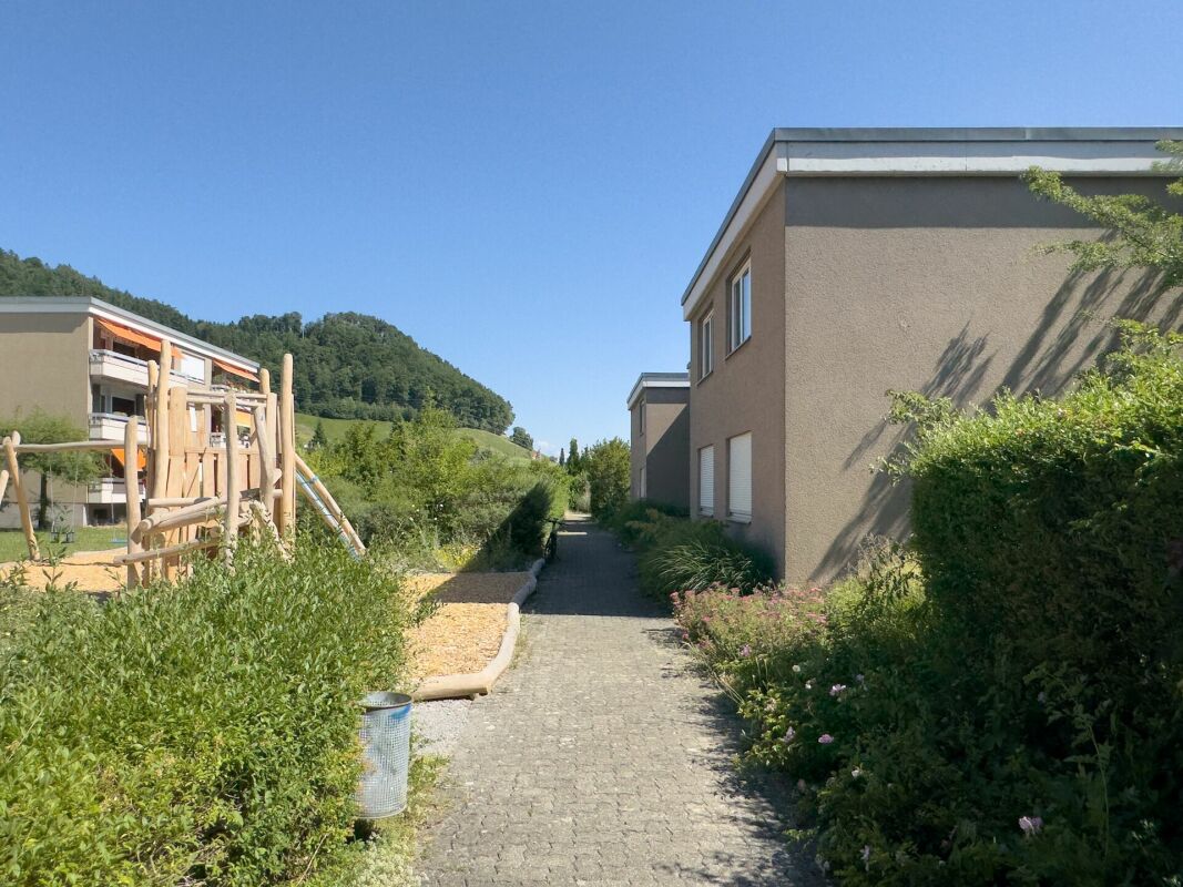 Außenansicht einer Wohnanlage mit Weg und Grünfläche