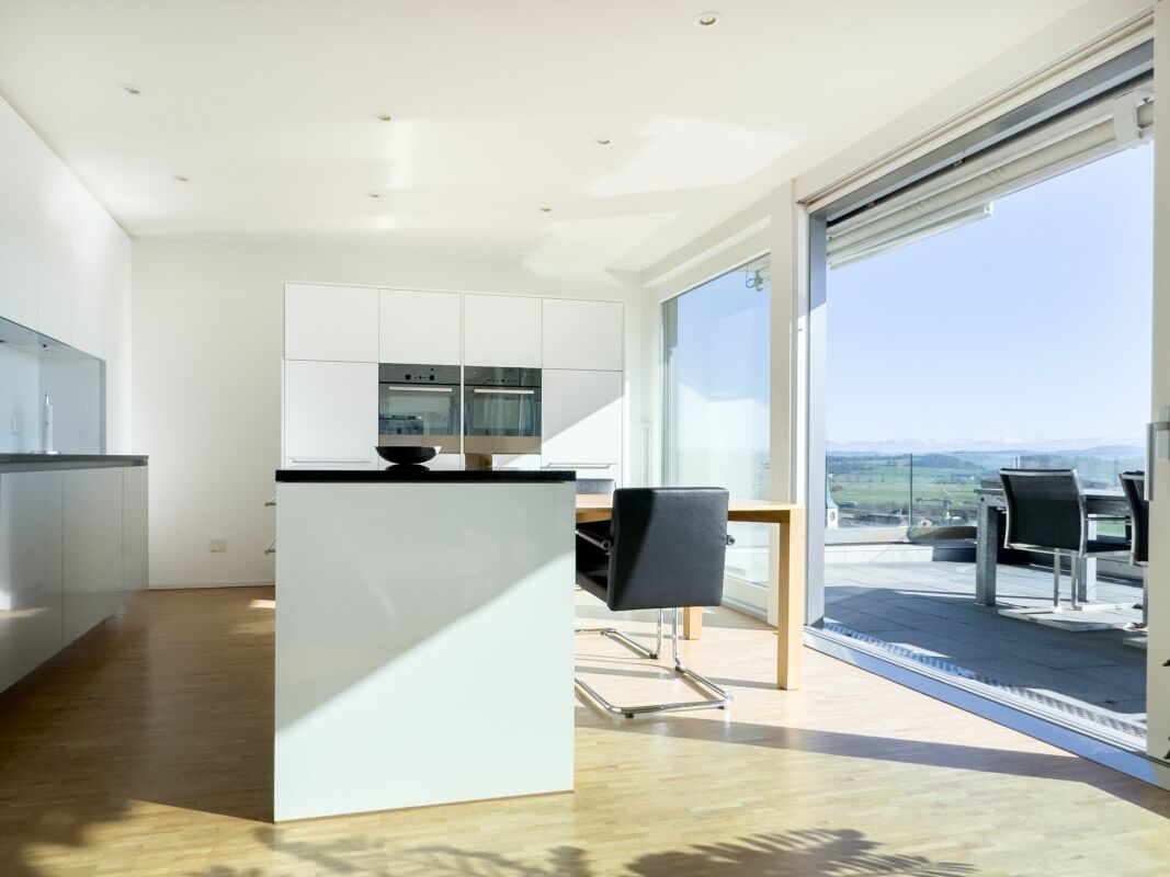 Helle moderne Wohnküche mit Terrasse und Aussicht
