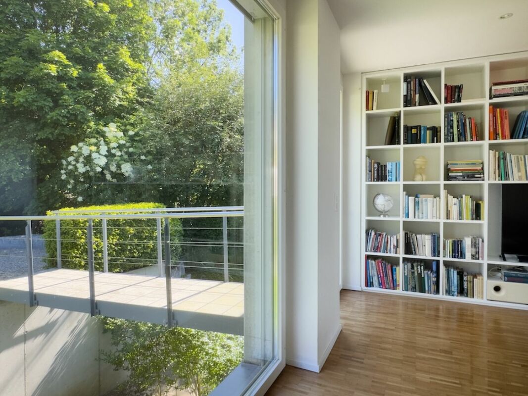 Heller Wohnraum mit großem Fenster und Bücherregal