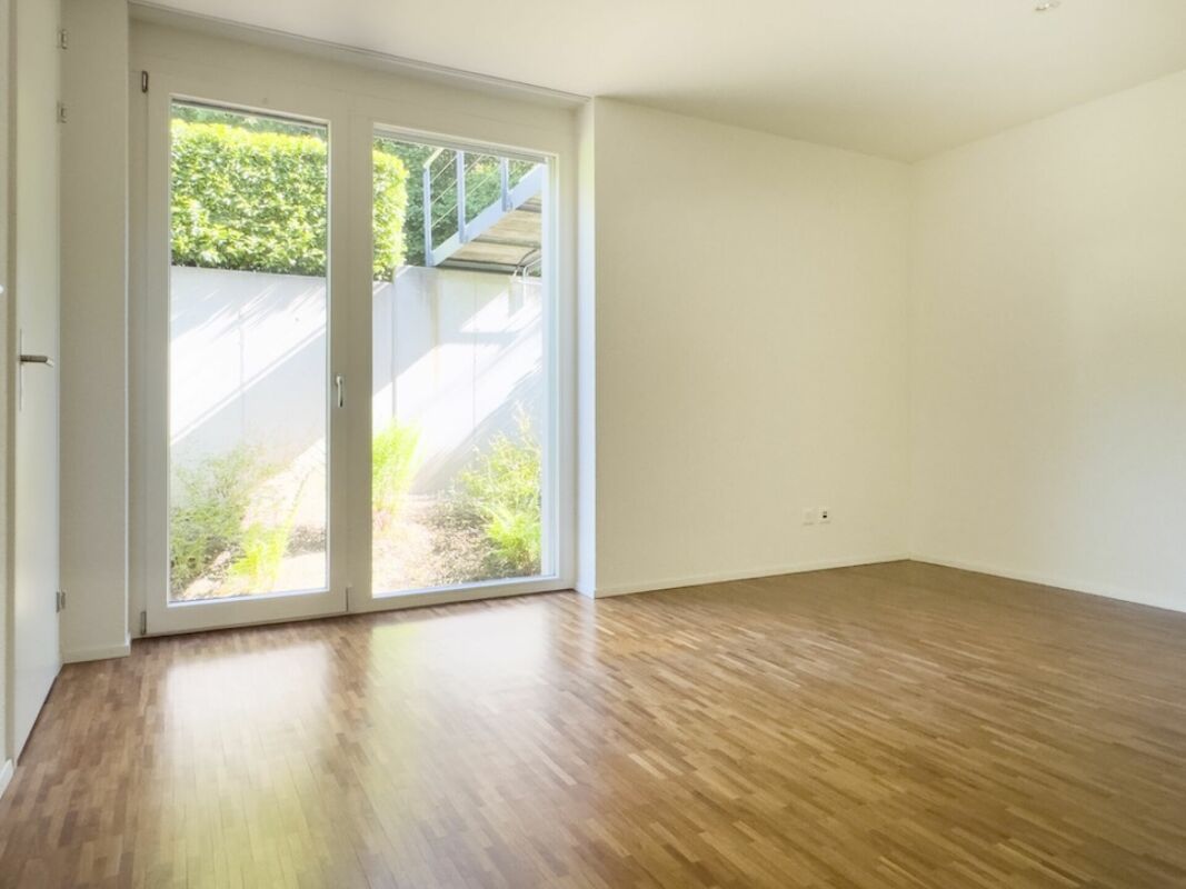 Leerer Wohnraum mit bodentiefer Terrassentür
