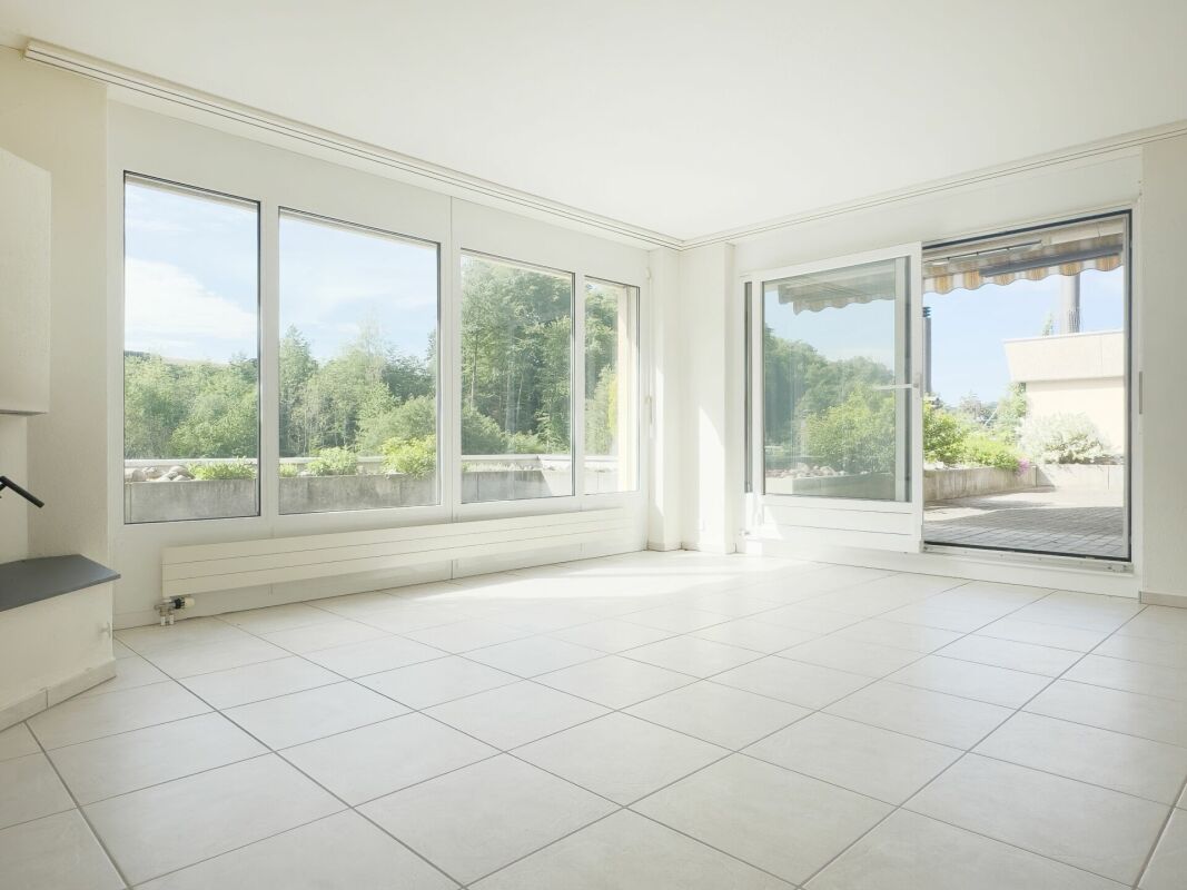 Heller, leerer Wohnraum mit großer Fensterfront