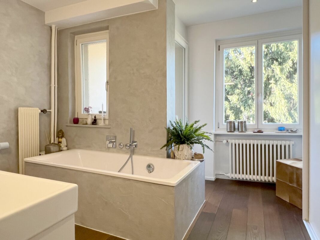 Modernes Badezimmer mit Badewanne und Gartenblick