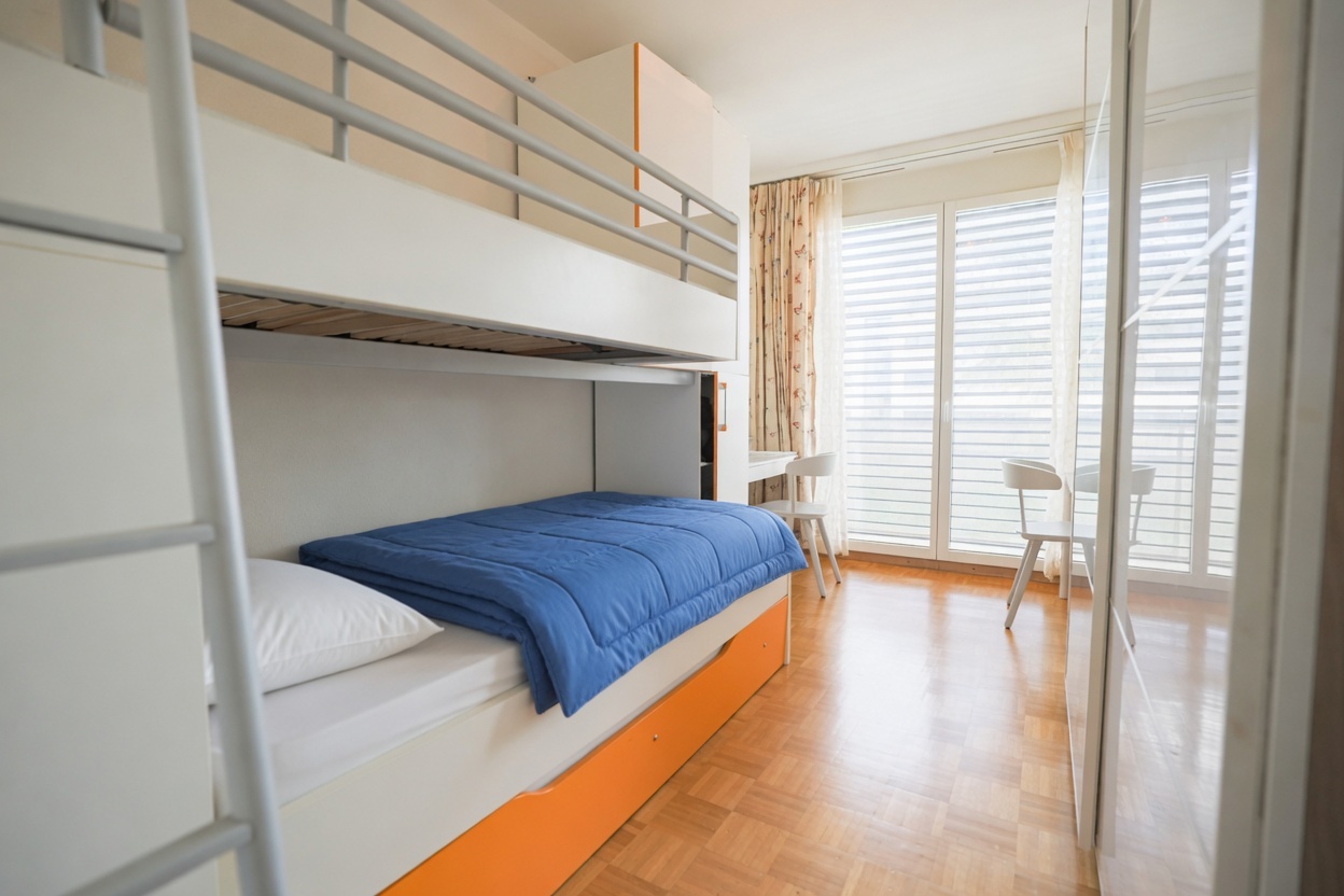 Schlafzimmer mit Etagenbett und Balkonfenster