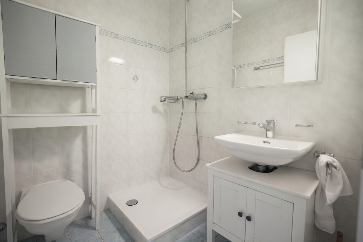 Kleines Bad mit Dusche und Waschtisch