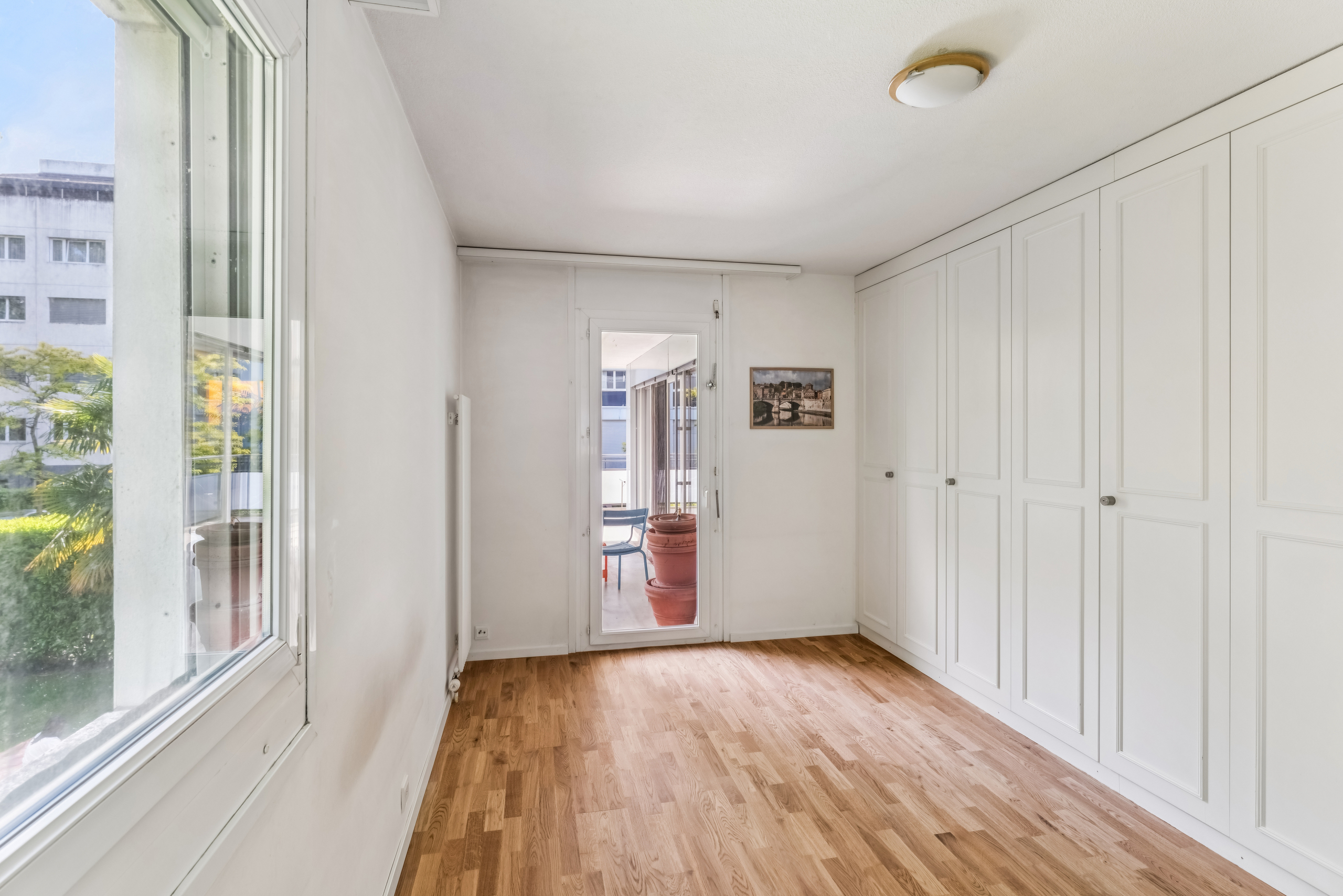 Helles Zimmer mit Einbauschränken und Balkonzugang