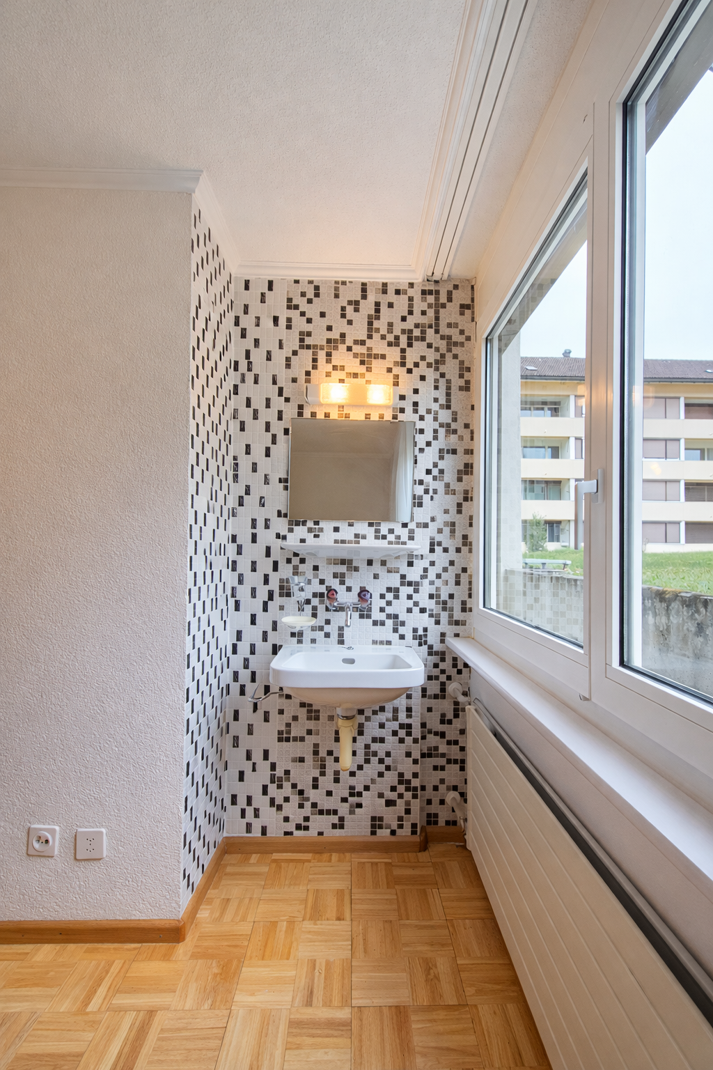 Kleines Waschbecken vor Fensterwand