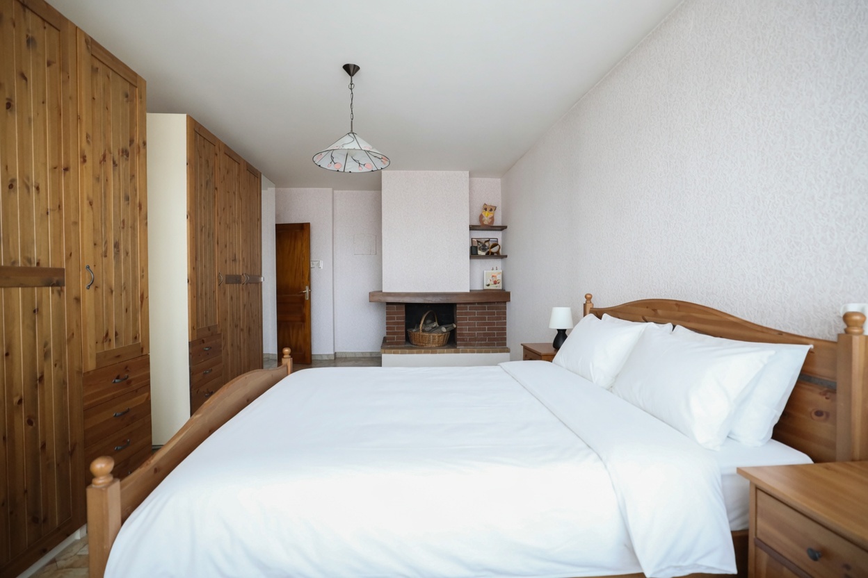 Schlafzimmer mit rustikalen Holzmöbeln und Kamin