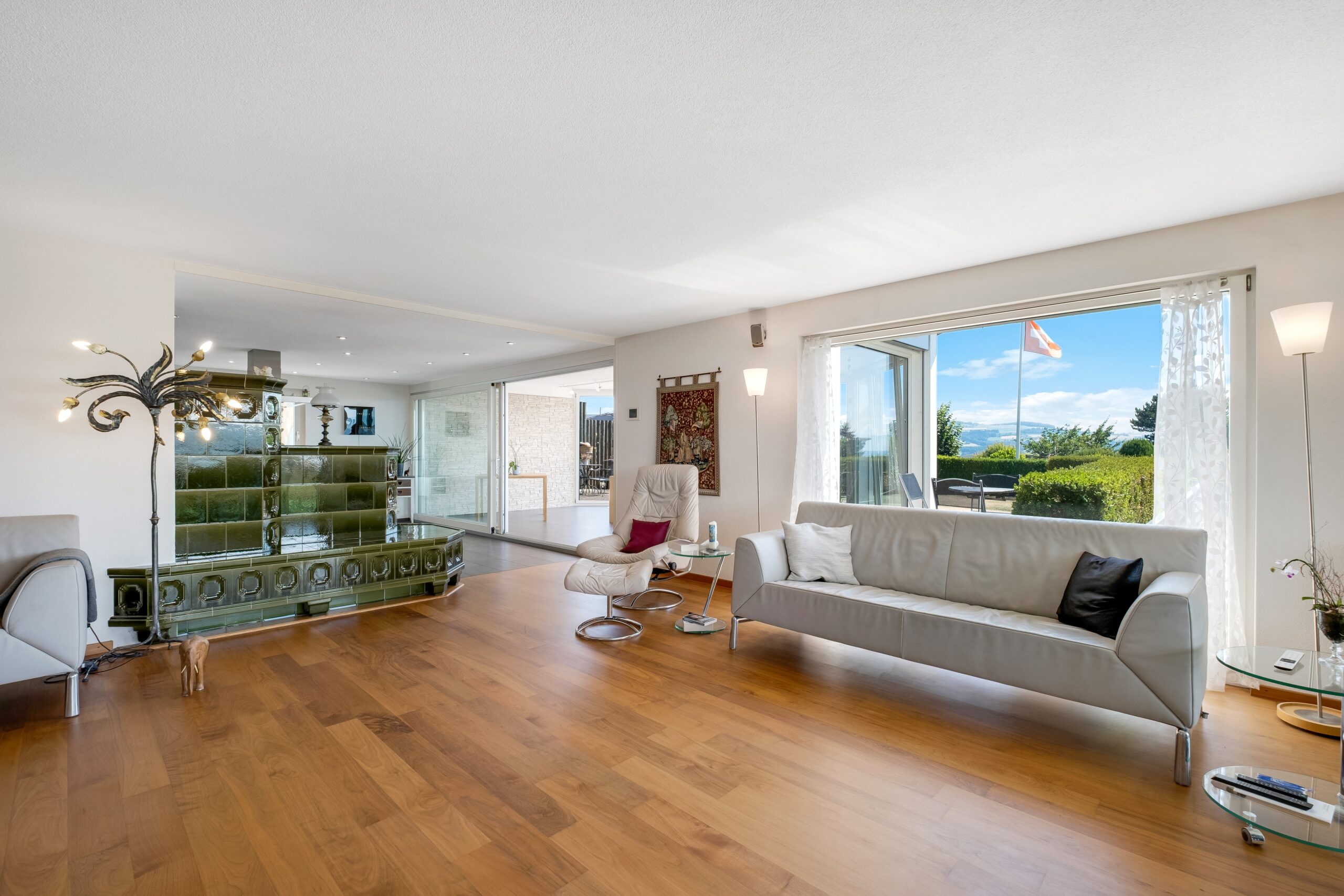 Helles Wohnzimmer mit Ausblick auf Terrasse und Landschaft