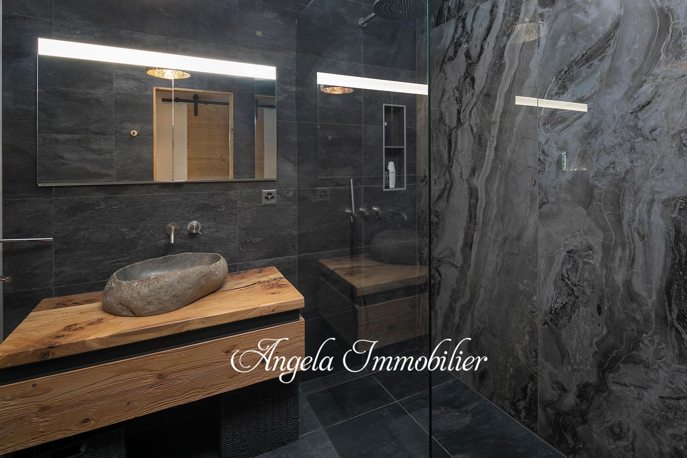 Luxuriöses Badezimmer mit Naturstein und Holzwaschtisch