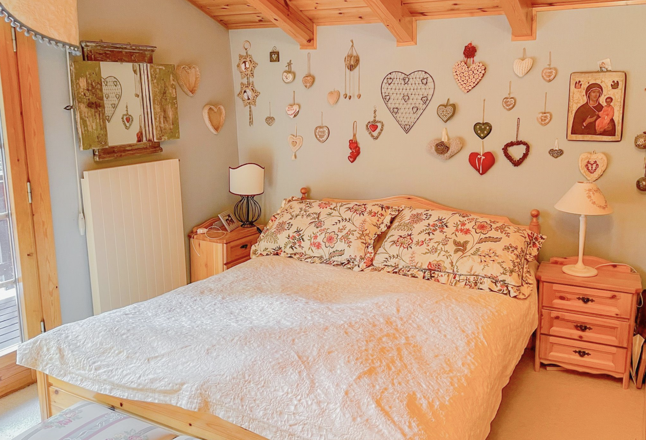 Gemütliches Schlafzimmer mit rustikaler Holzausstattung und vielen Herz-Dekorationen
