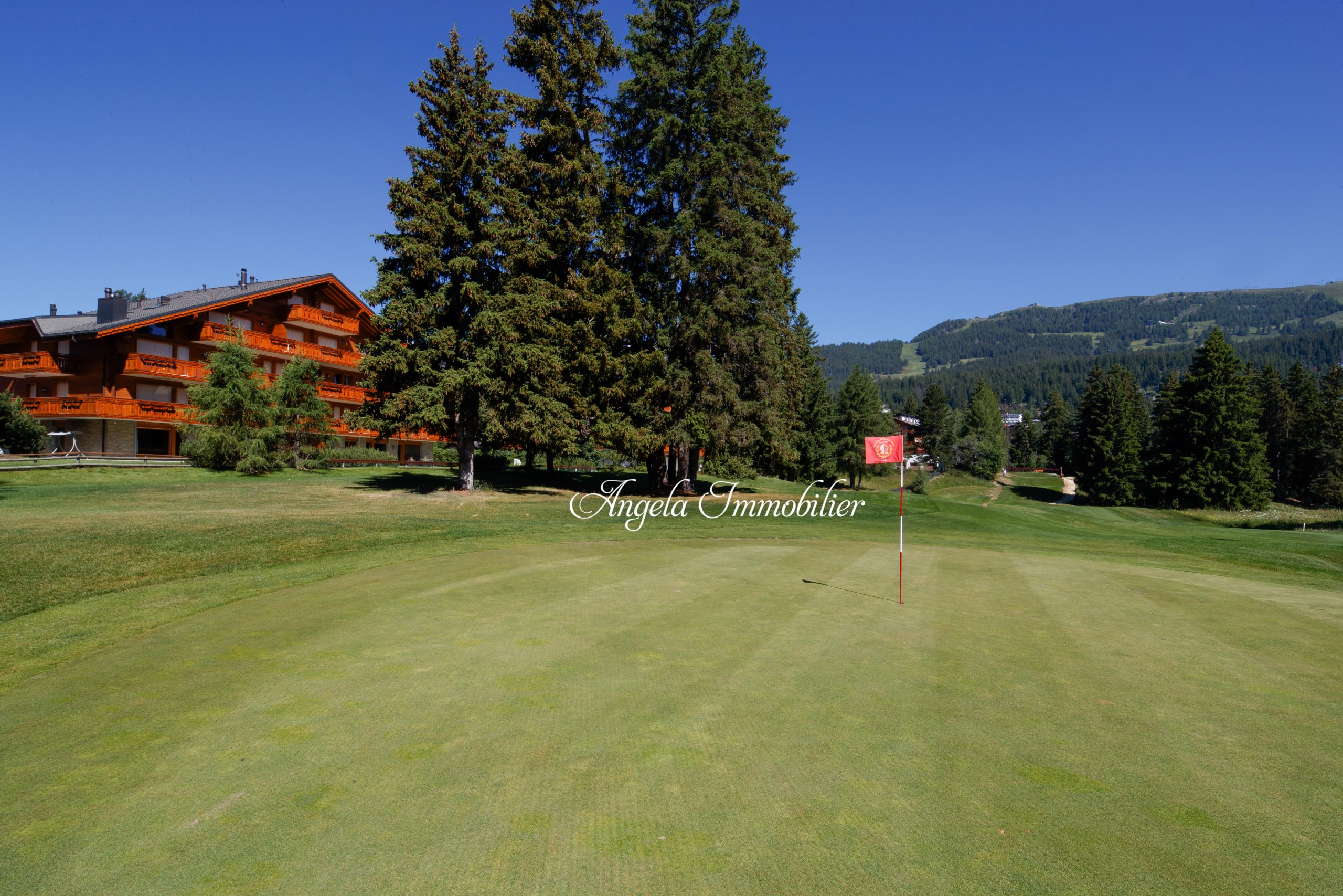 Golfanlage mit Chalet-Hotel und Bergblick