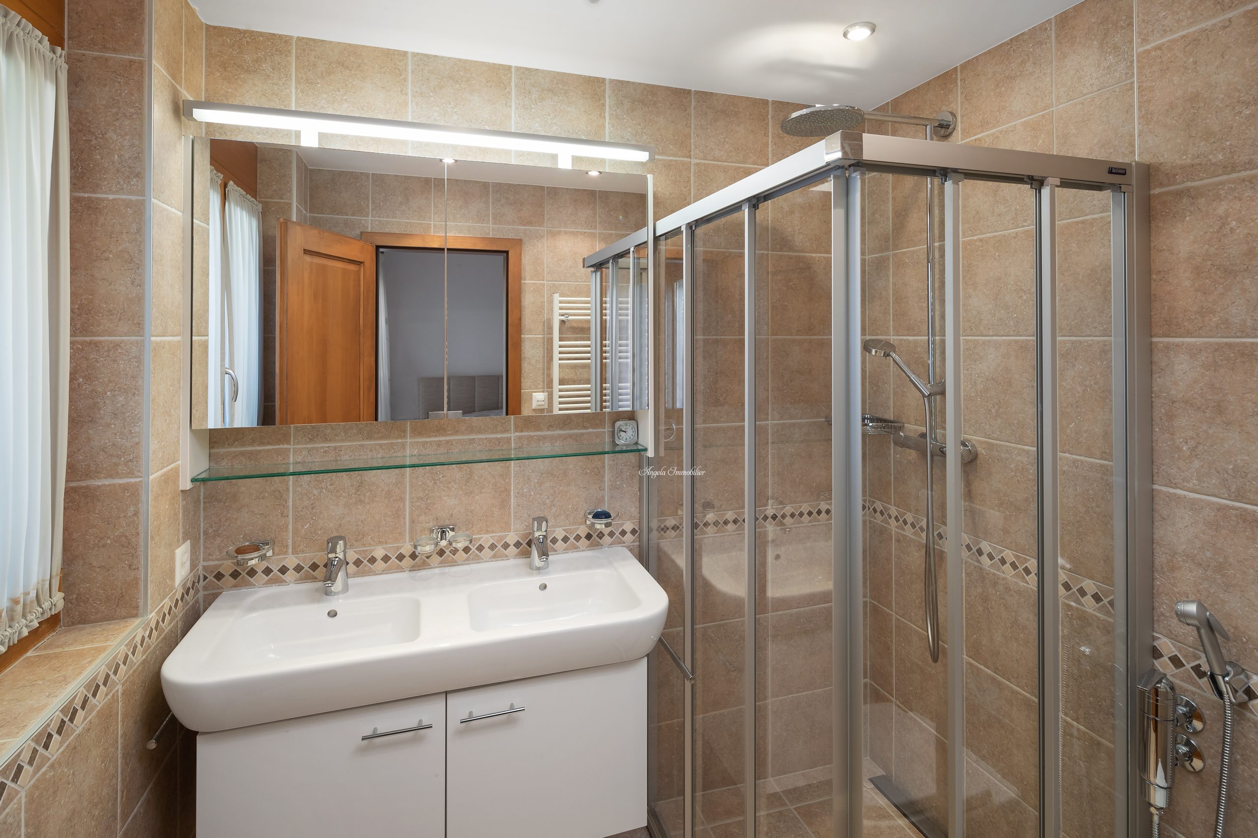 Modernes Badezimmer mit Glasdusche und Doppelwaschbecken