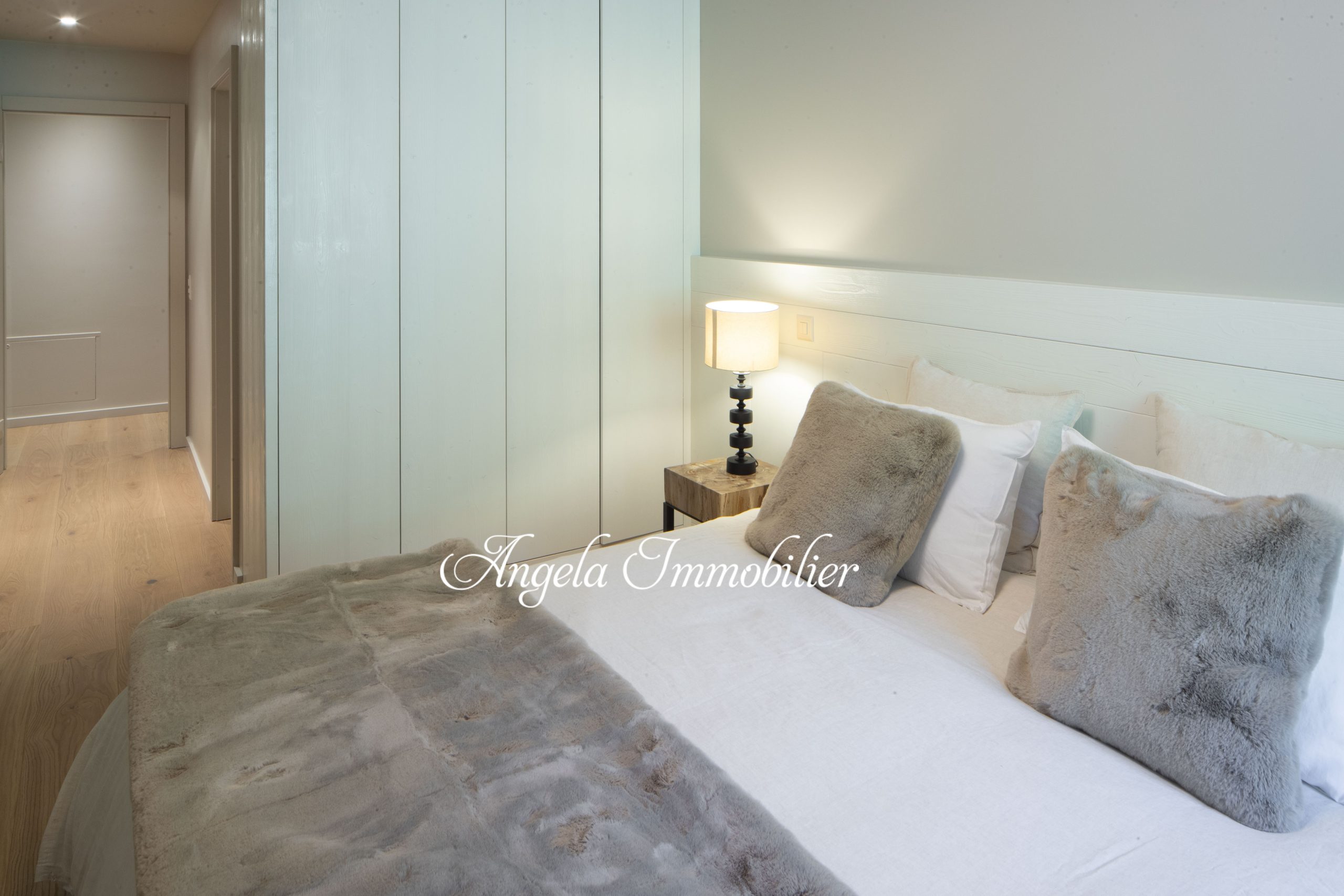Helles, modernes Schlafzimmer mit Doppelbett und Flurzugang