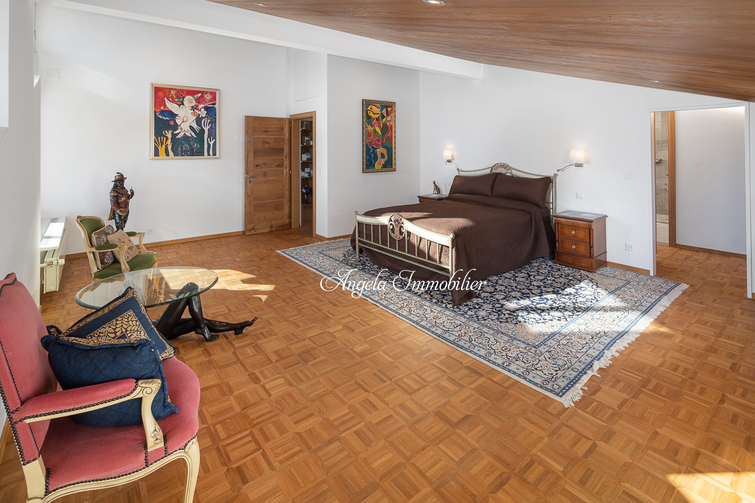 Großes Schlafzimmer mit Holzparkett und antiken Möbeln