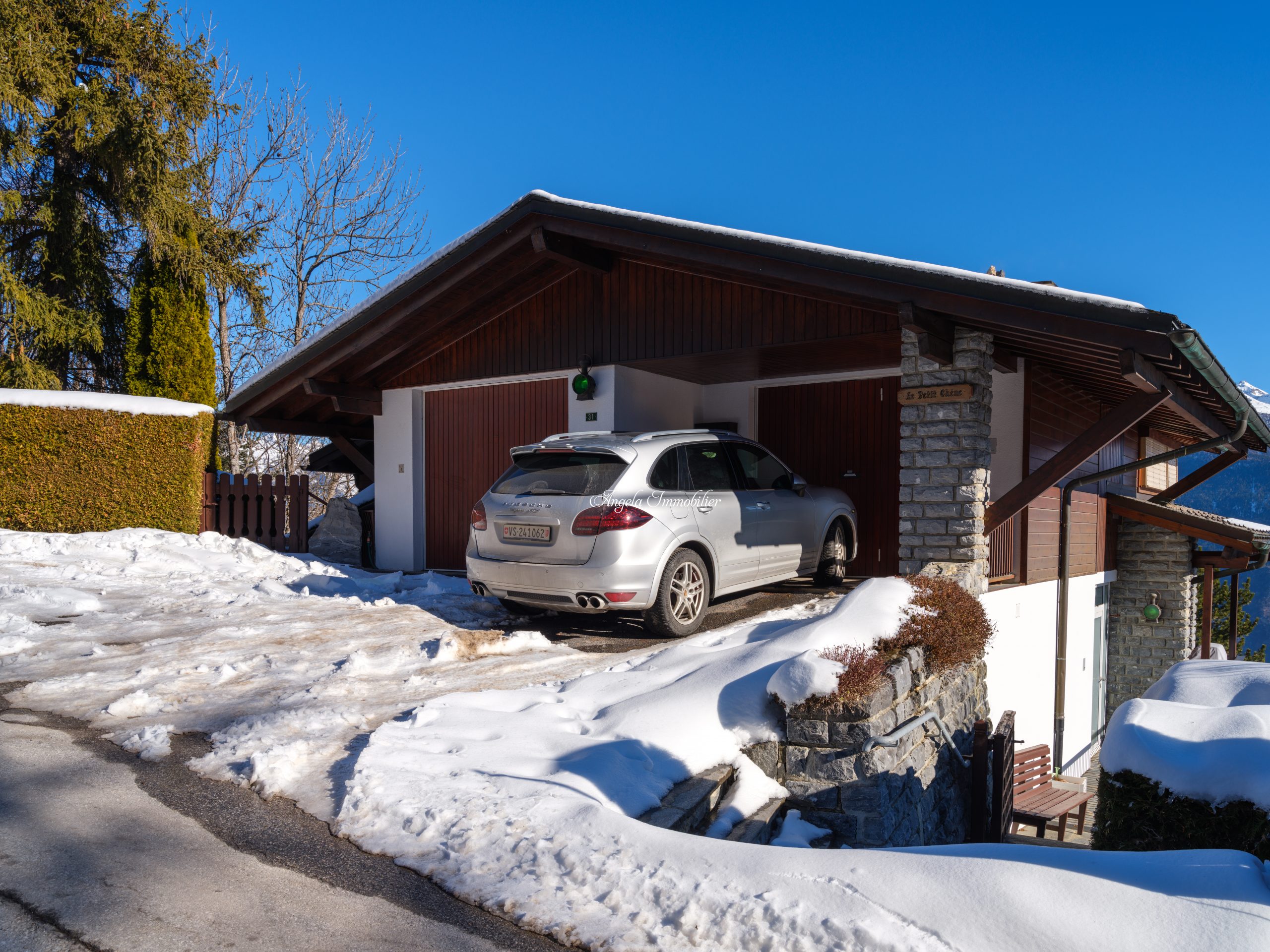 Schneebedecktes Chalet mit Carport