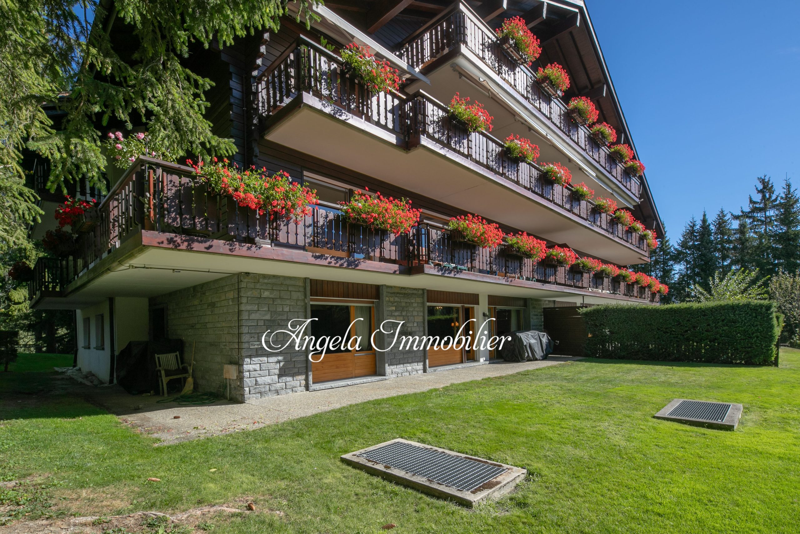 Alpenstil-Mehrfamilienhaus mit Balkonblumen