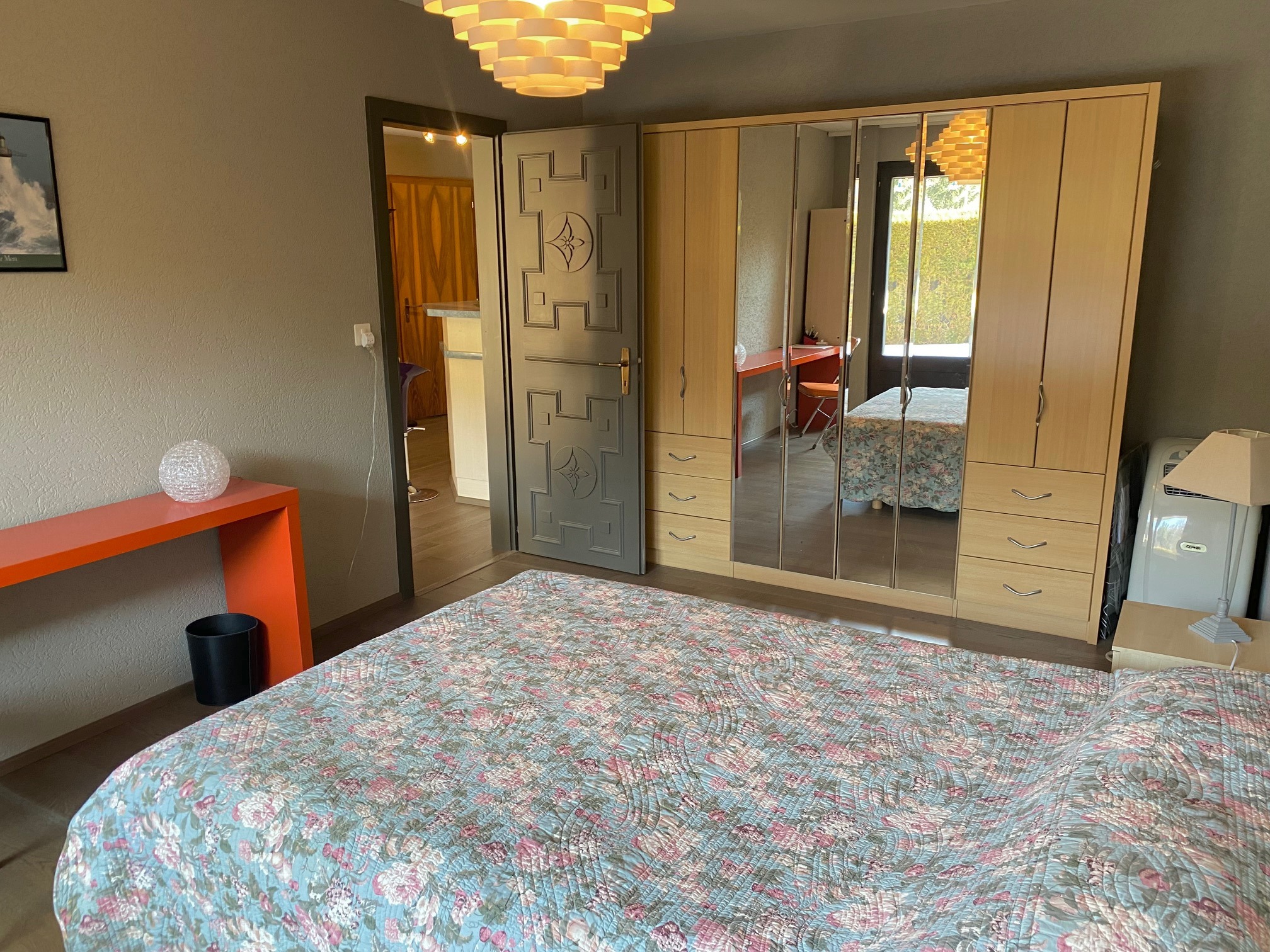 Schlafzimmer mit Bett, Kleiderschrank und Schreibtisch
