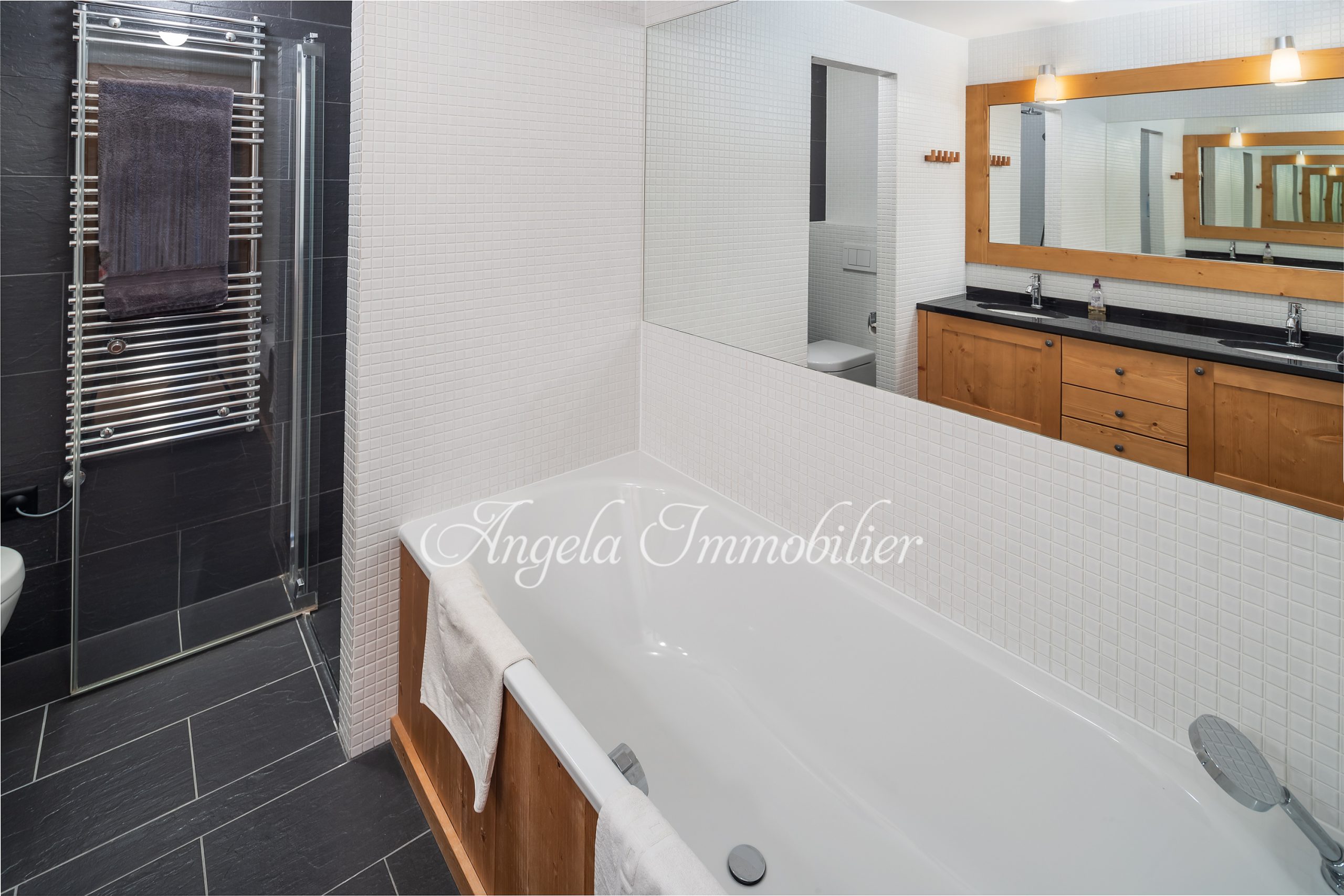 Modernes Badezimmer mit Badewanne und dunkler Dusche