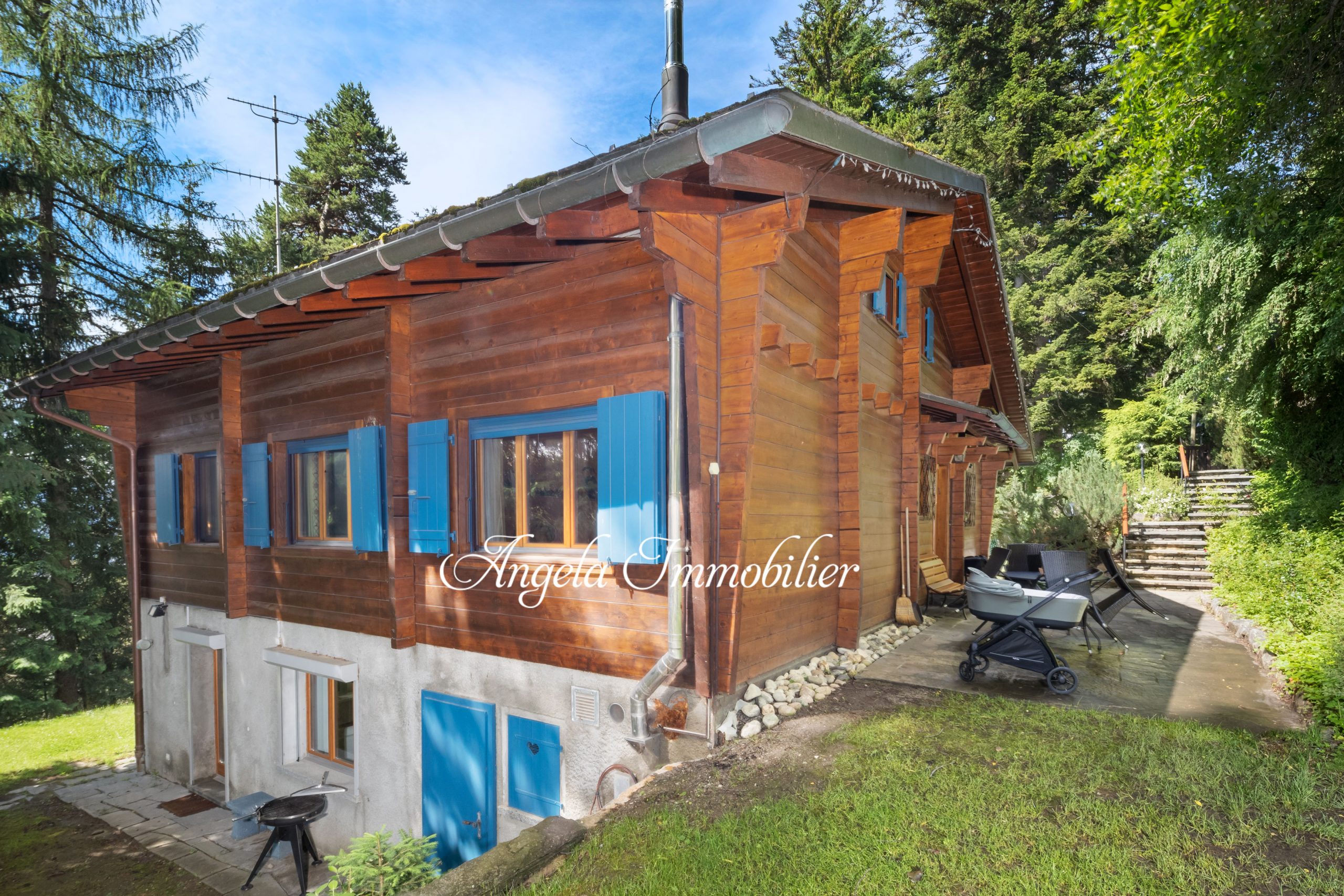 Holzhaus mit blau lackierten Fensterläden im Grünen