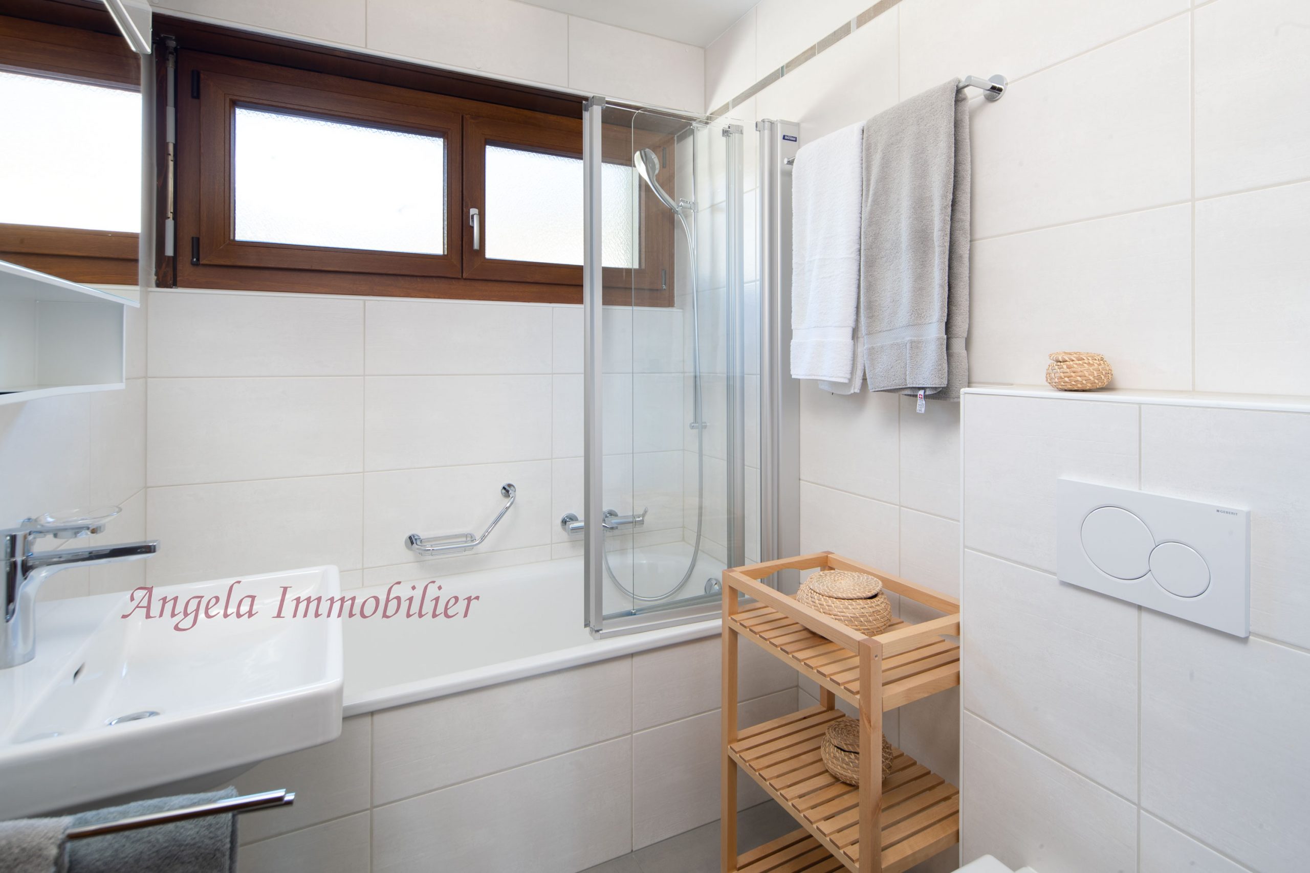 Helles Badezimmer mit Badewanne, Duschabtrennung und Holzfenster