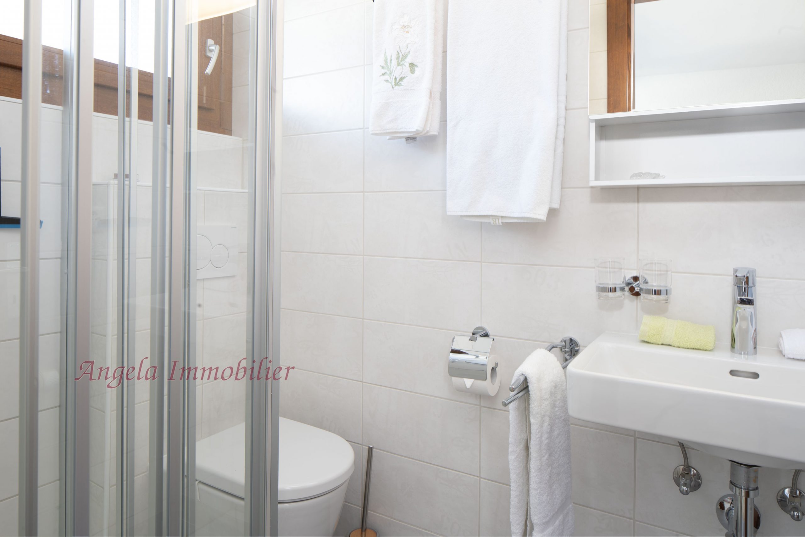Kleines helles Badezimmer mit Dusche und Waschbecken