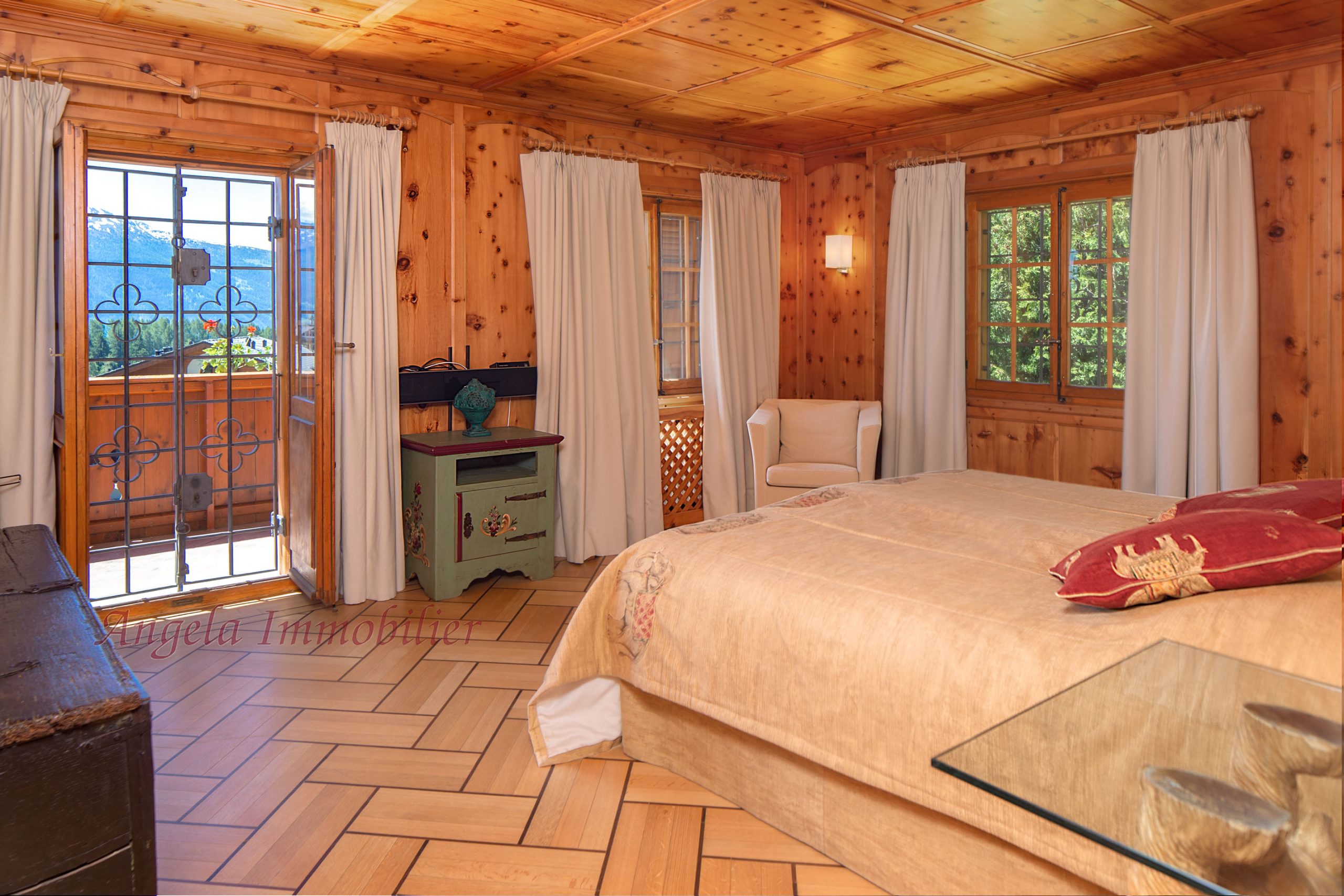 Gemütliches Schlafzimmer mit Holzverkleidung und Bergblick