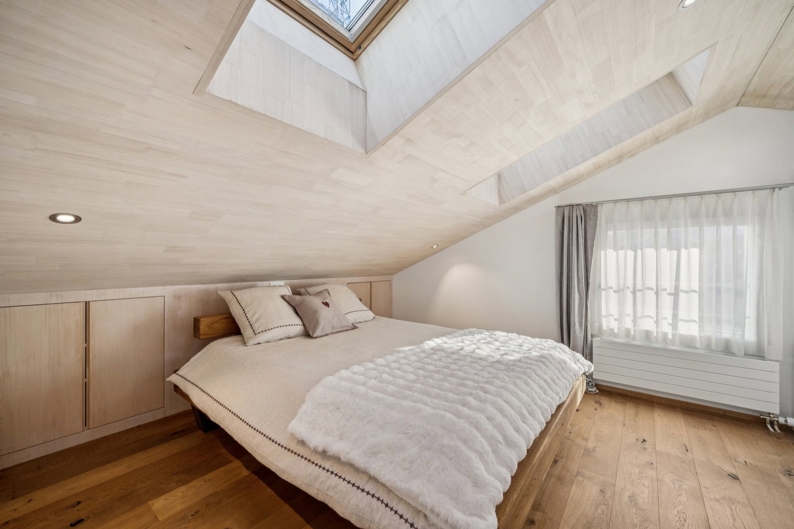 Dachgeschoss-Schlafzimmer mit hellem Holz und Schrägen
