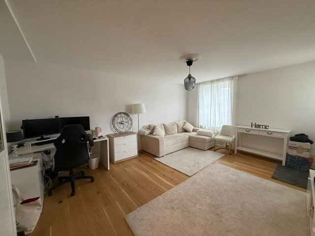 Helles Wohn-/Arbeitszimmer mit Sofa und Schreibtisch