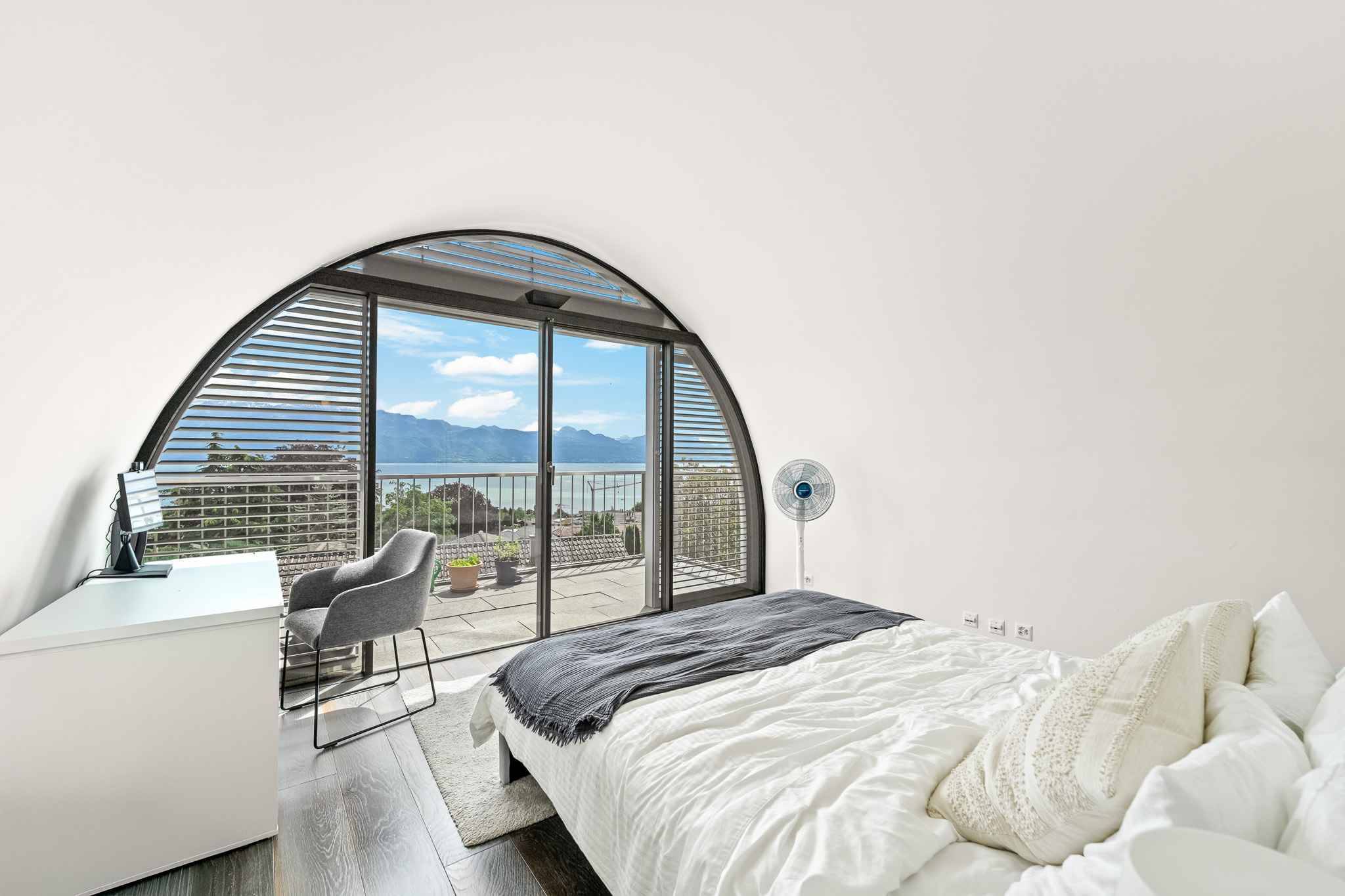 Schlafzimmer mit Panoramafenster und Seeblick